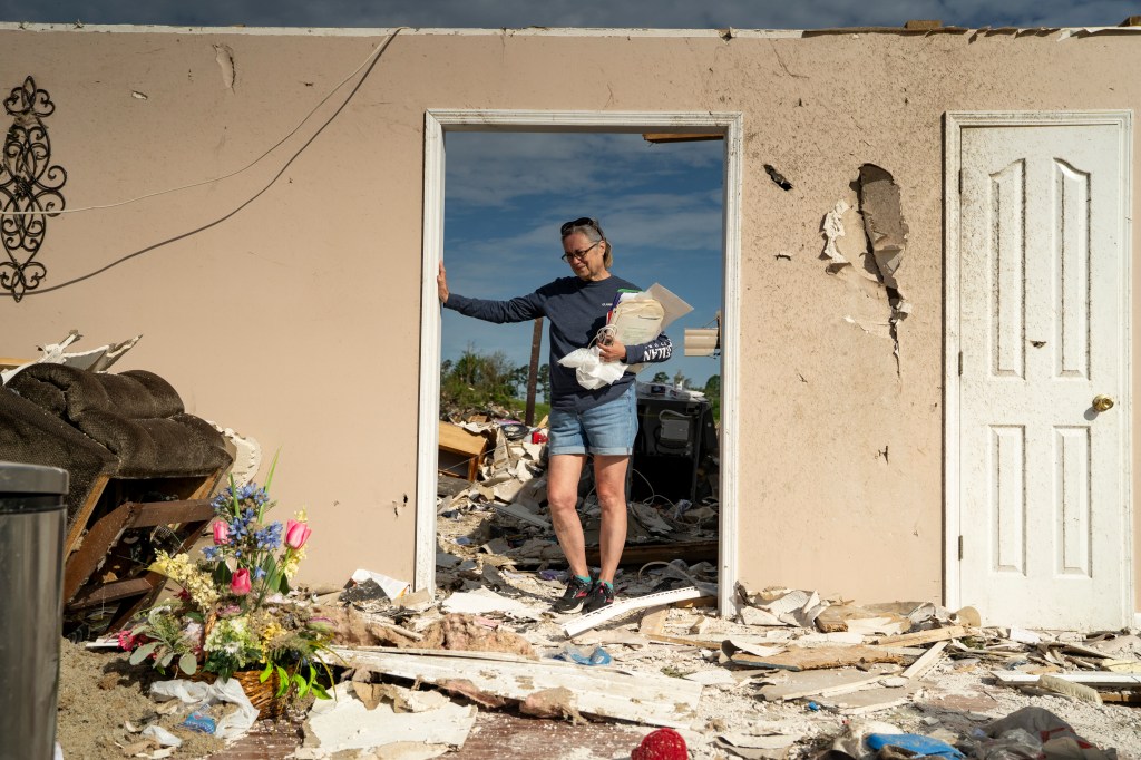 Lesly Karen Cornett standing amidst the debris of her house destroyed by a tornado, in Sunshine Hills community, London, Kentucky, May 18, 2025.