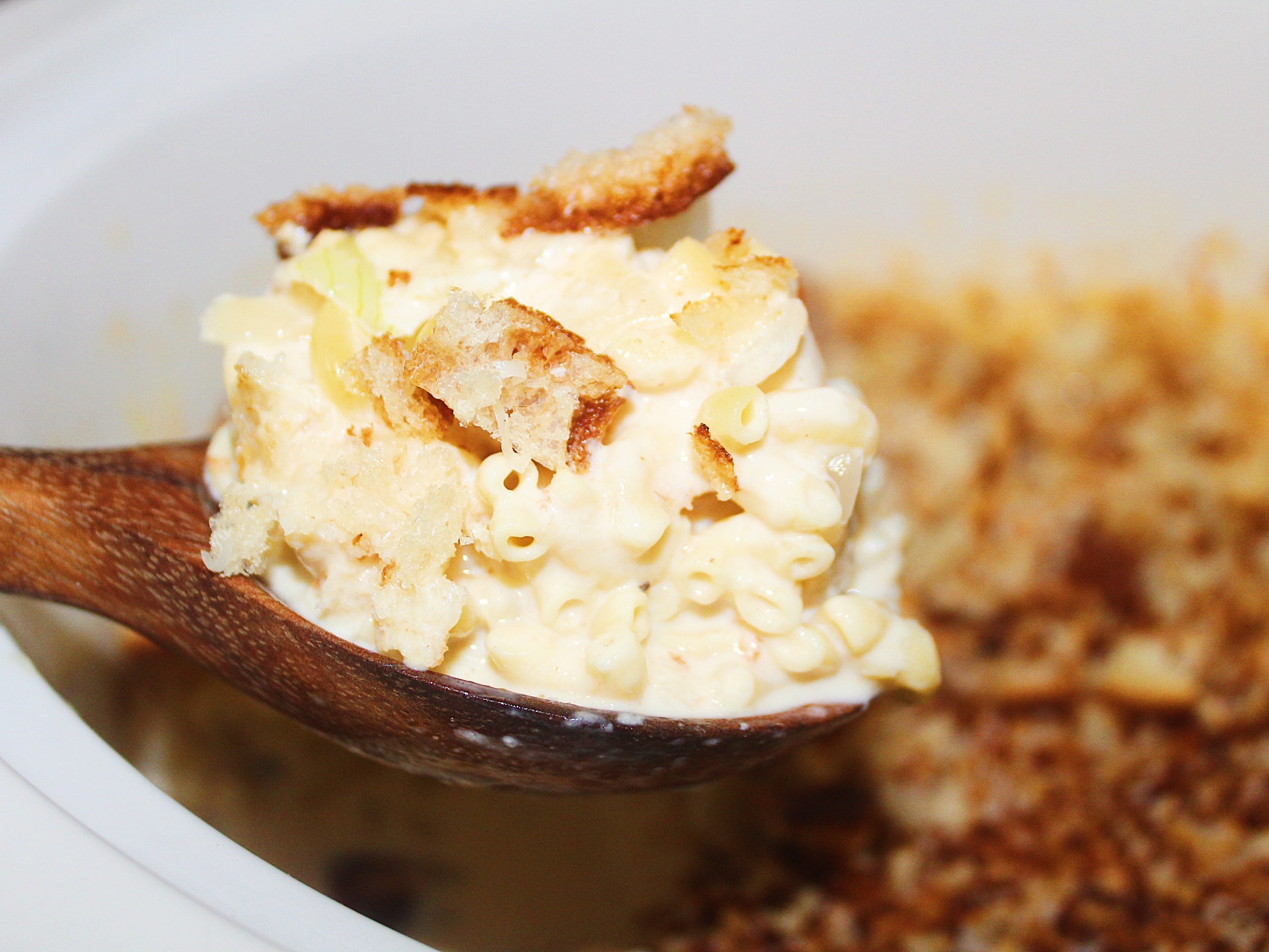 a wooden spoon of finished mac and cheese