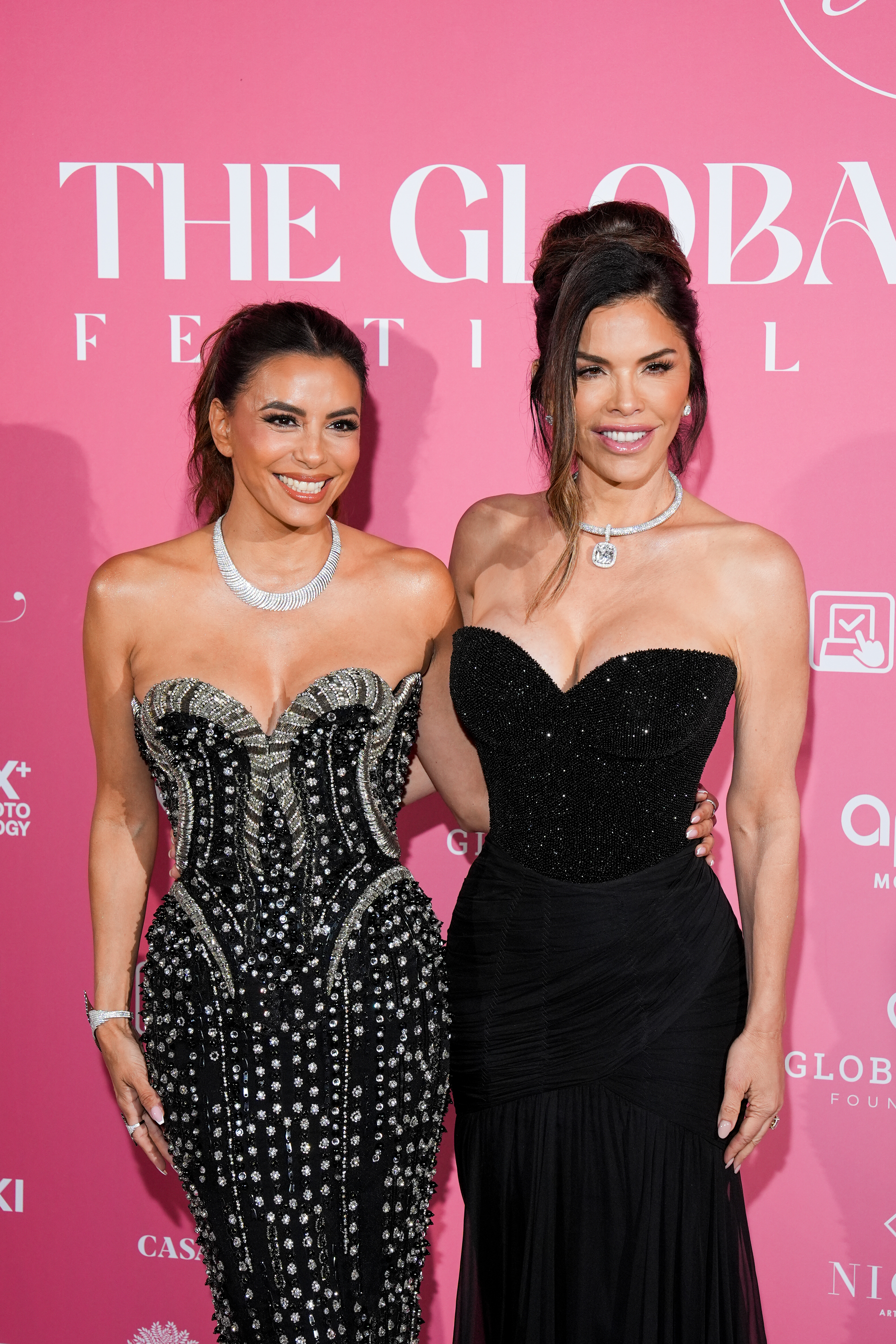 Lauren Sánchez and Eva Longoria smile on the carpet at a formal event. 