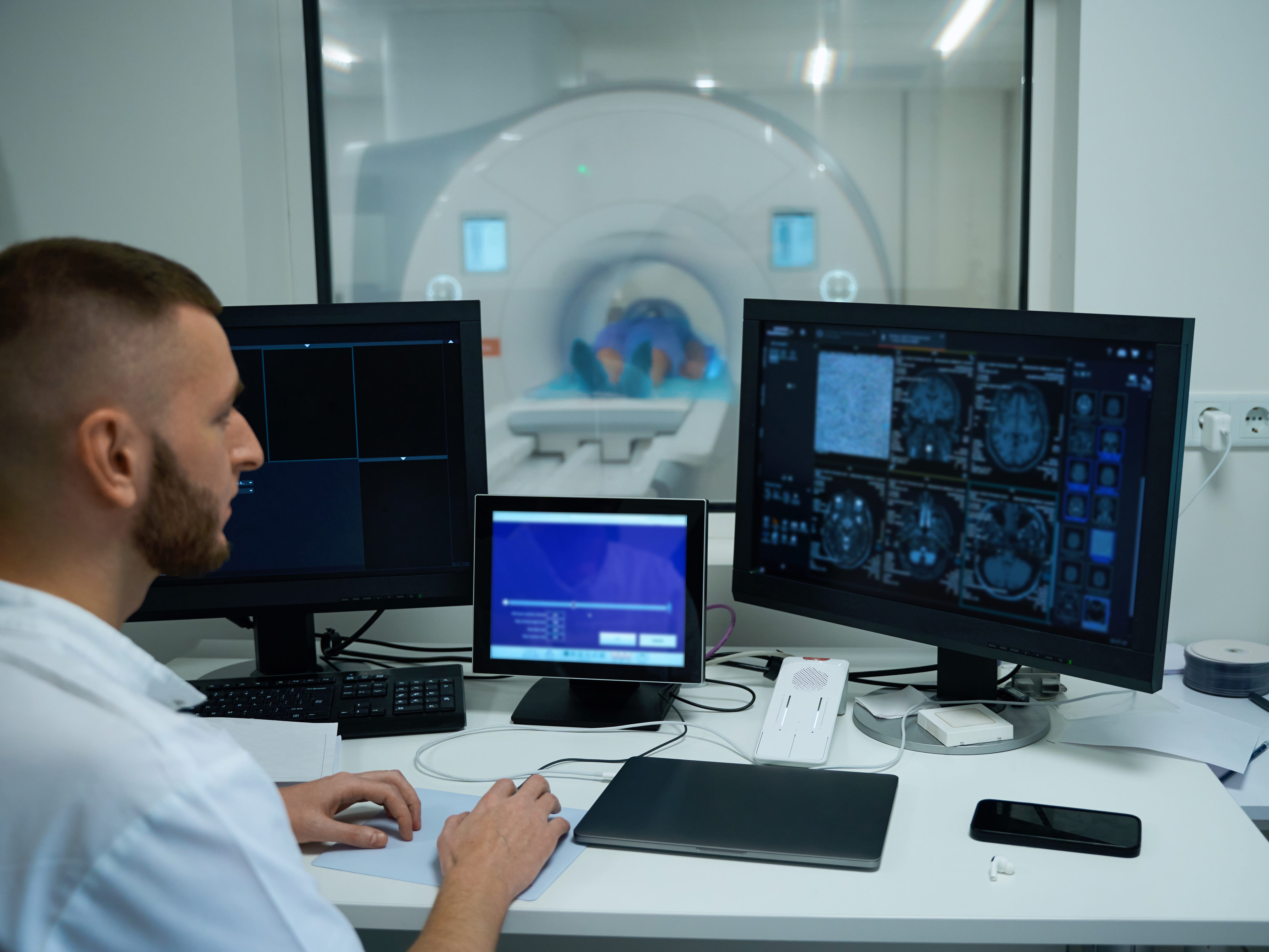 Healthcare worker, technologist, looking at MRI scans