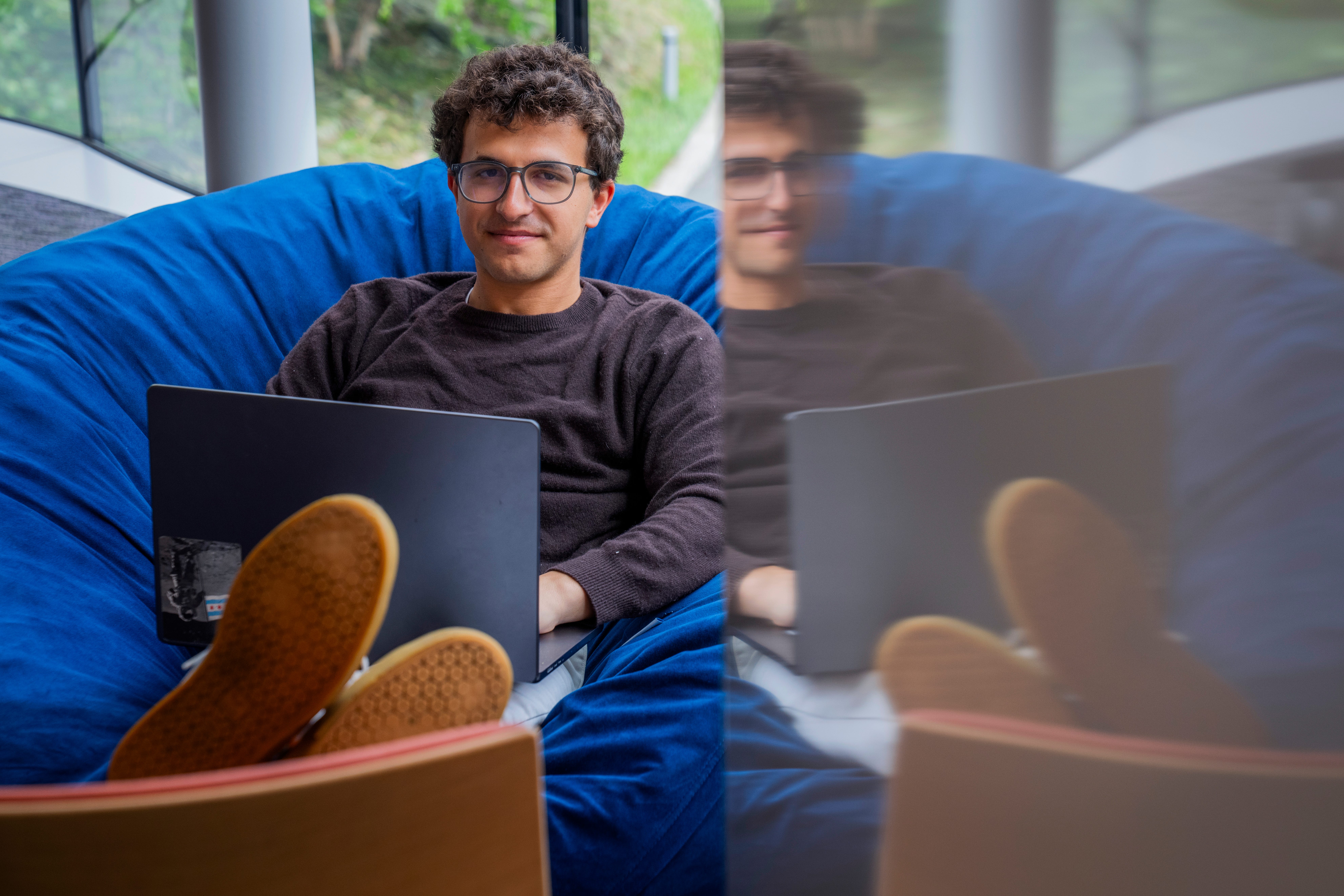 Alex Schapiro sits in a couch with his laptop
