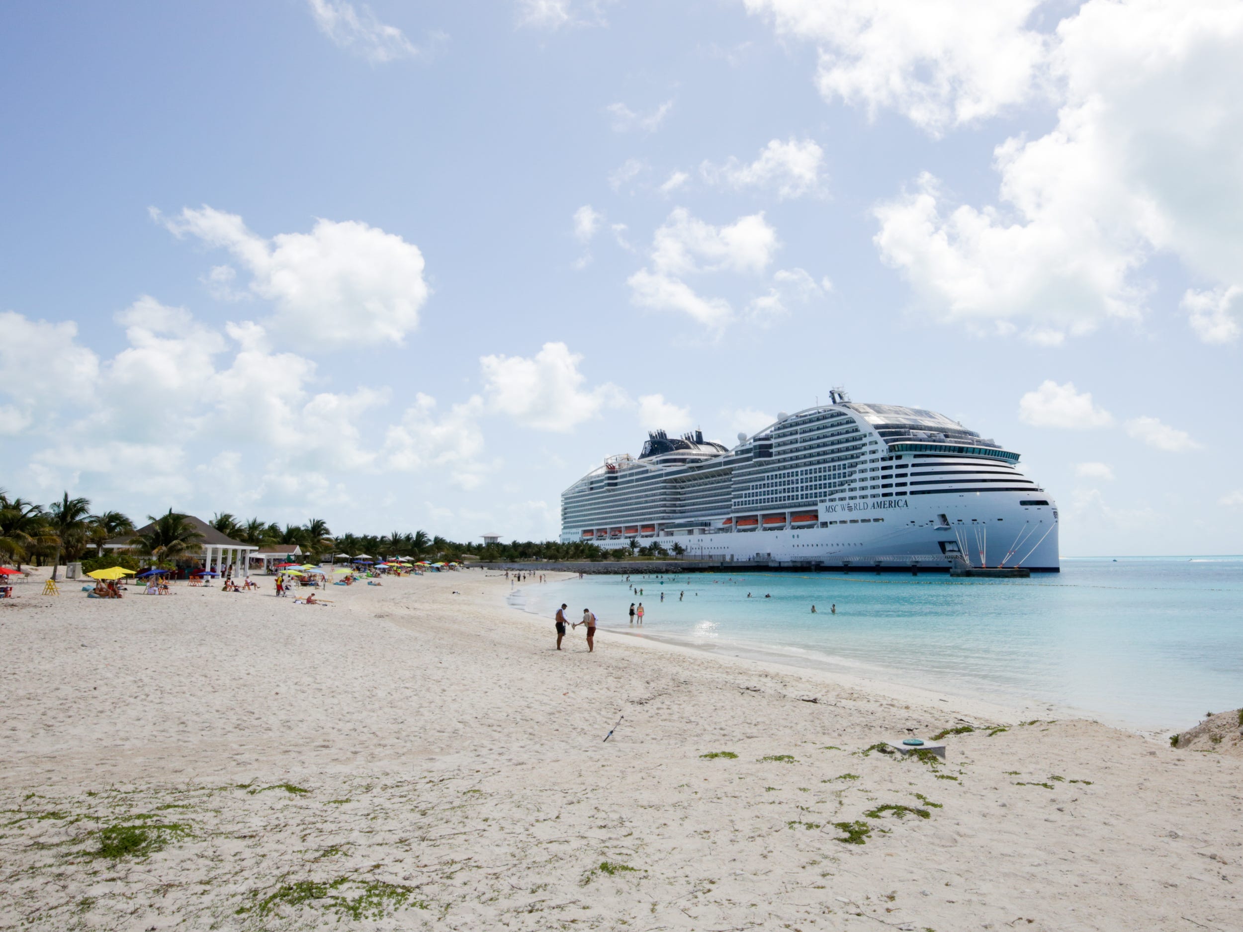 MSC World America docked at the cruise line's private island, Ocean Cay near a beach with people