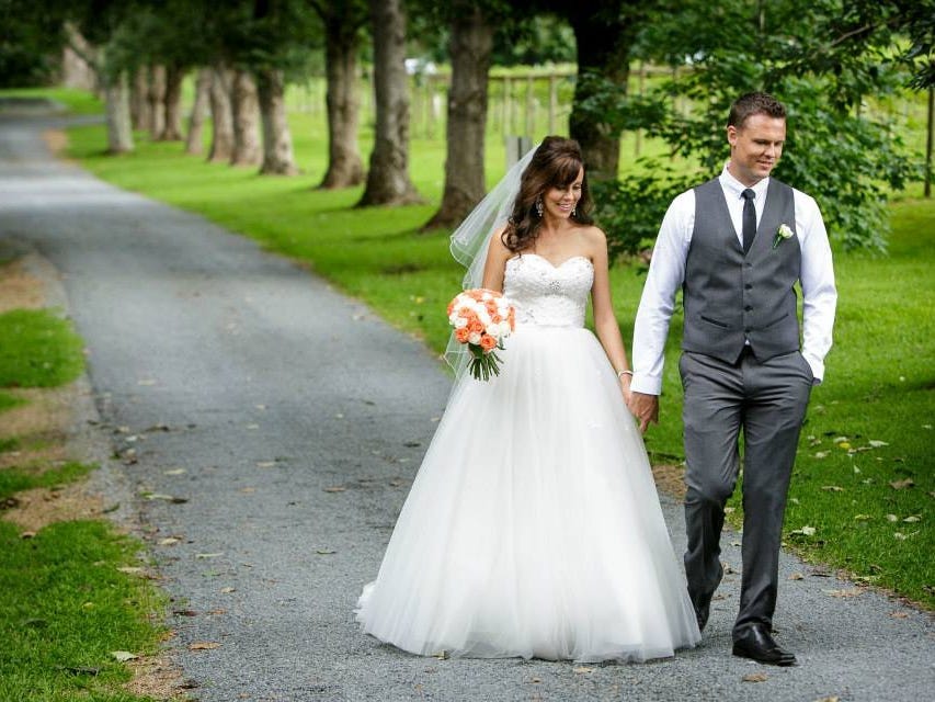 The author and her husband walking down a pathway in the park on their wedding day.