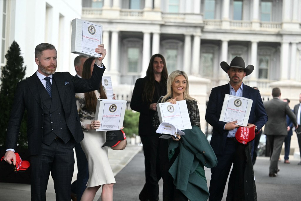 Unidentified individuals exiting the West Wing of the White House carrying binders labeled 'The Epstein Files: Phase 1', adorned with the US Justice Department seal, on February 27, 2025