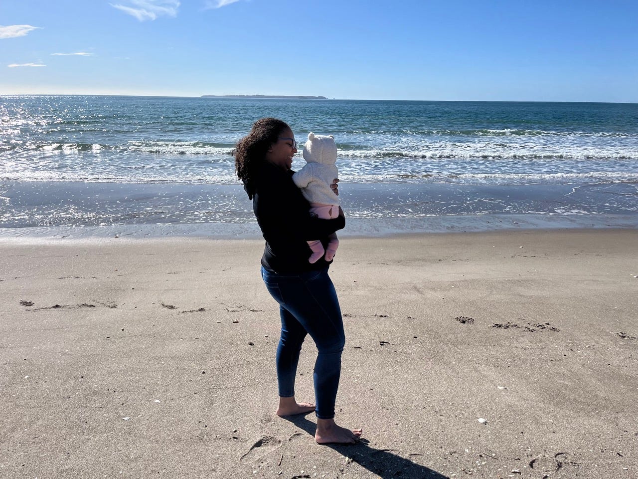 Author Alejandra Rojas holding her baby on a beach