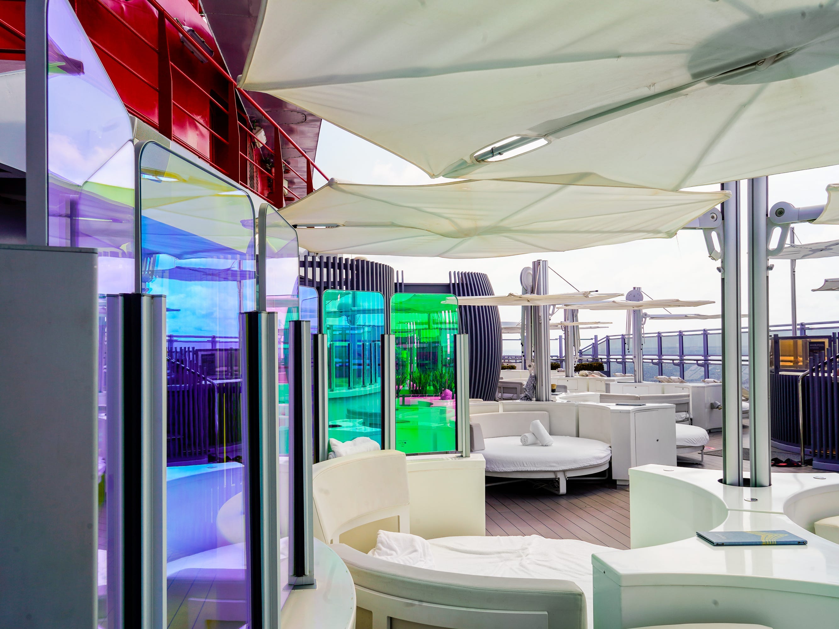 White couches and umbrellas with iridescent glass dividers