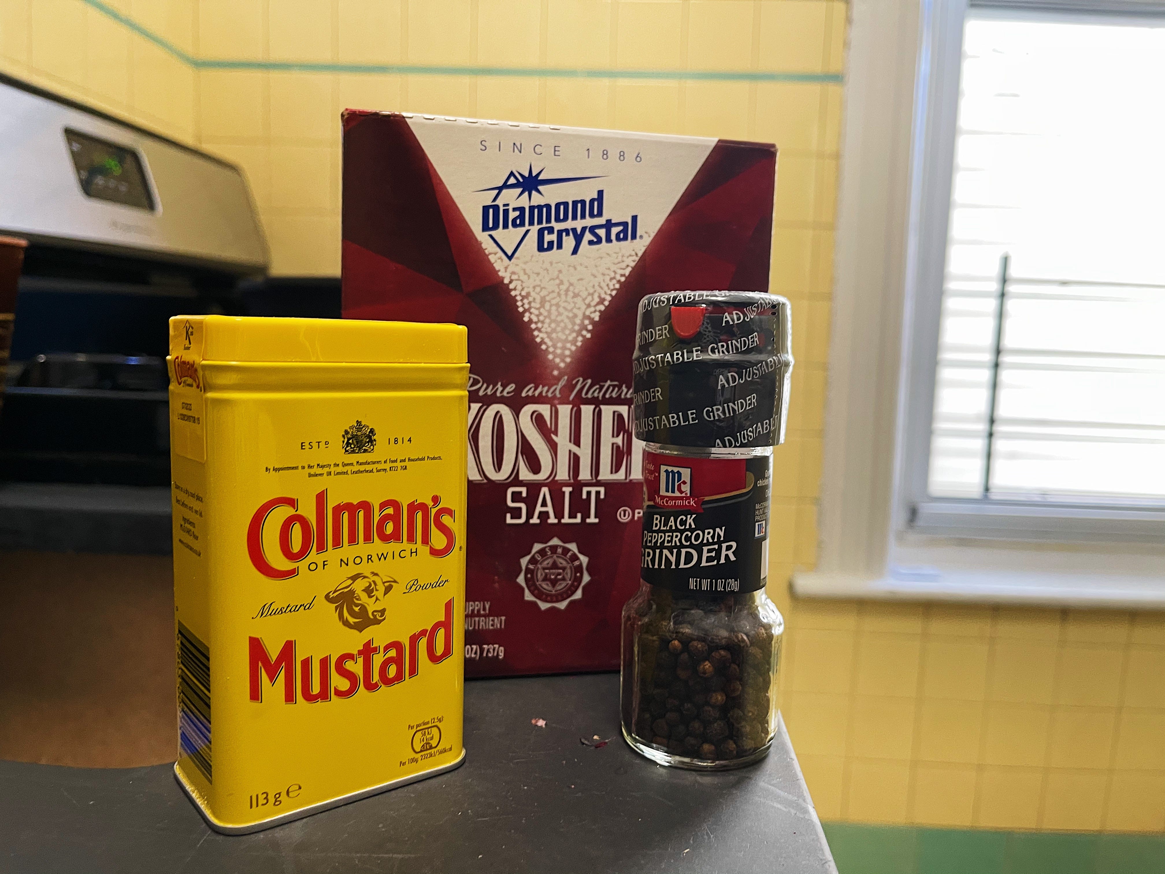 colman's mustard powder, black pepper, and kosher salt on a counter