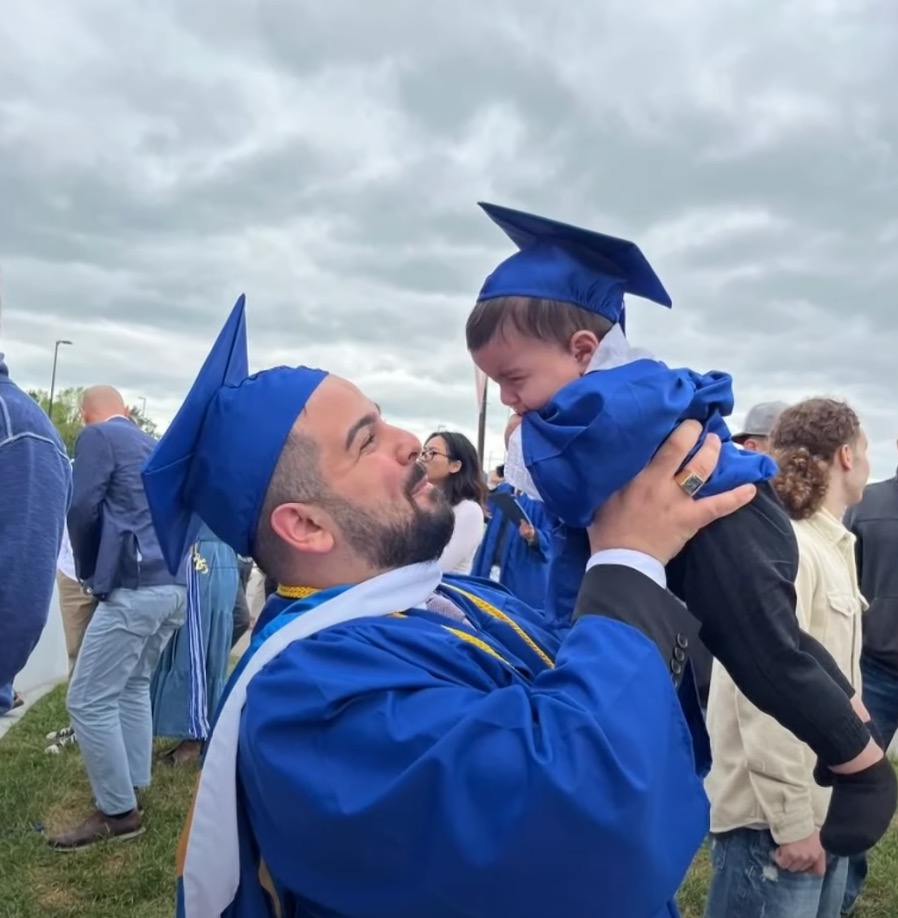 Al Arab holds his son, wearing a matching blue cap and gown, in a picture to celebrate his graduation.