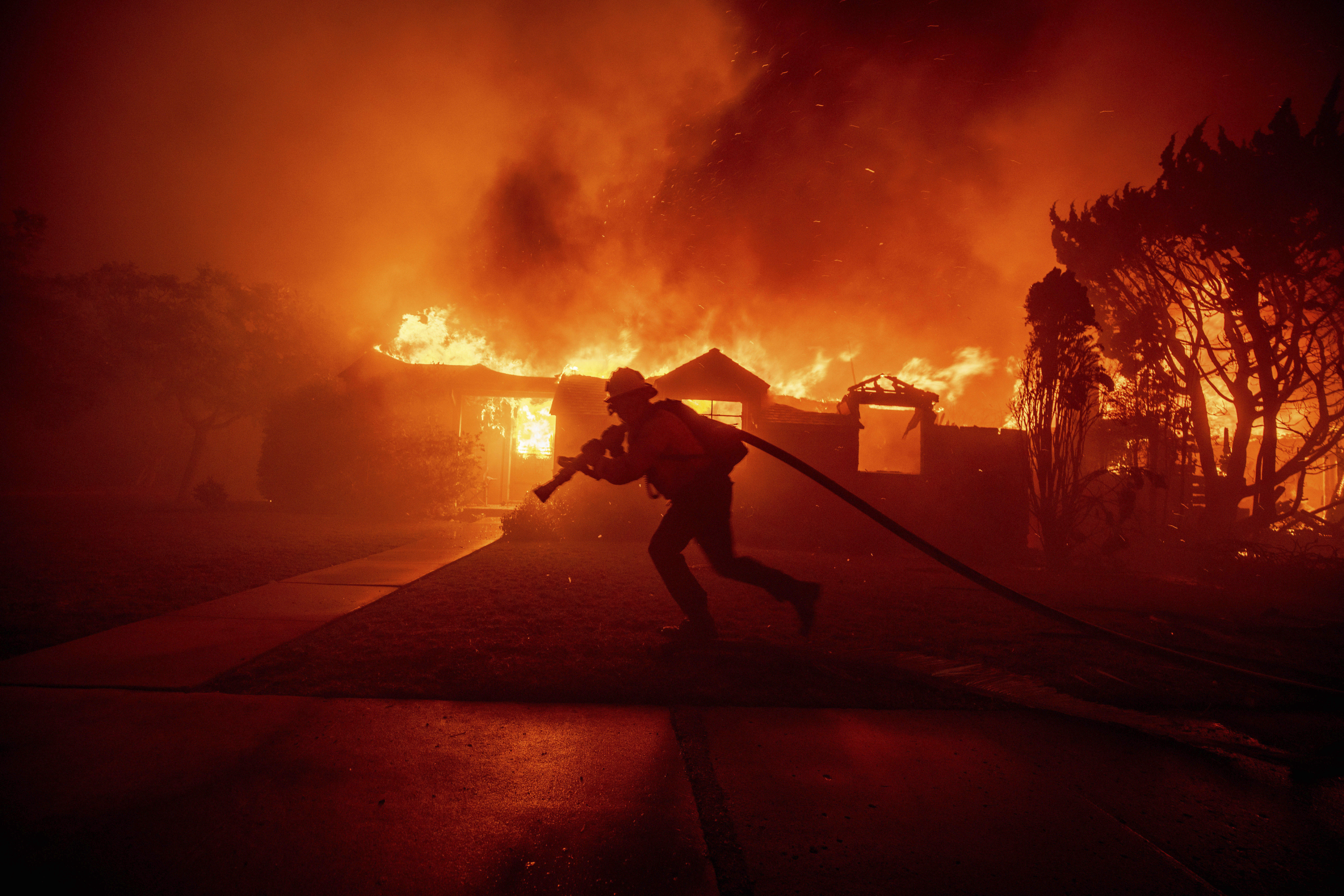 A firefighter battles the Palisades Fire.