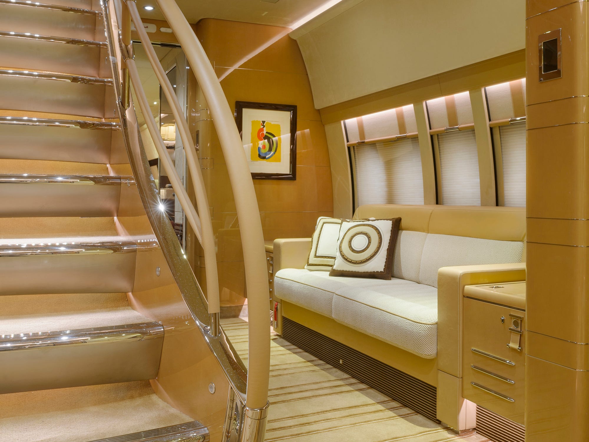 couches next to a staircase on a BOEING 747-8i BBJ