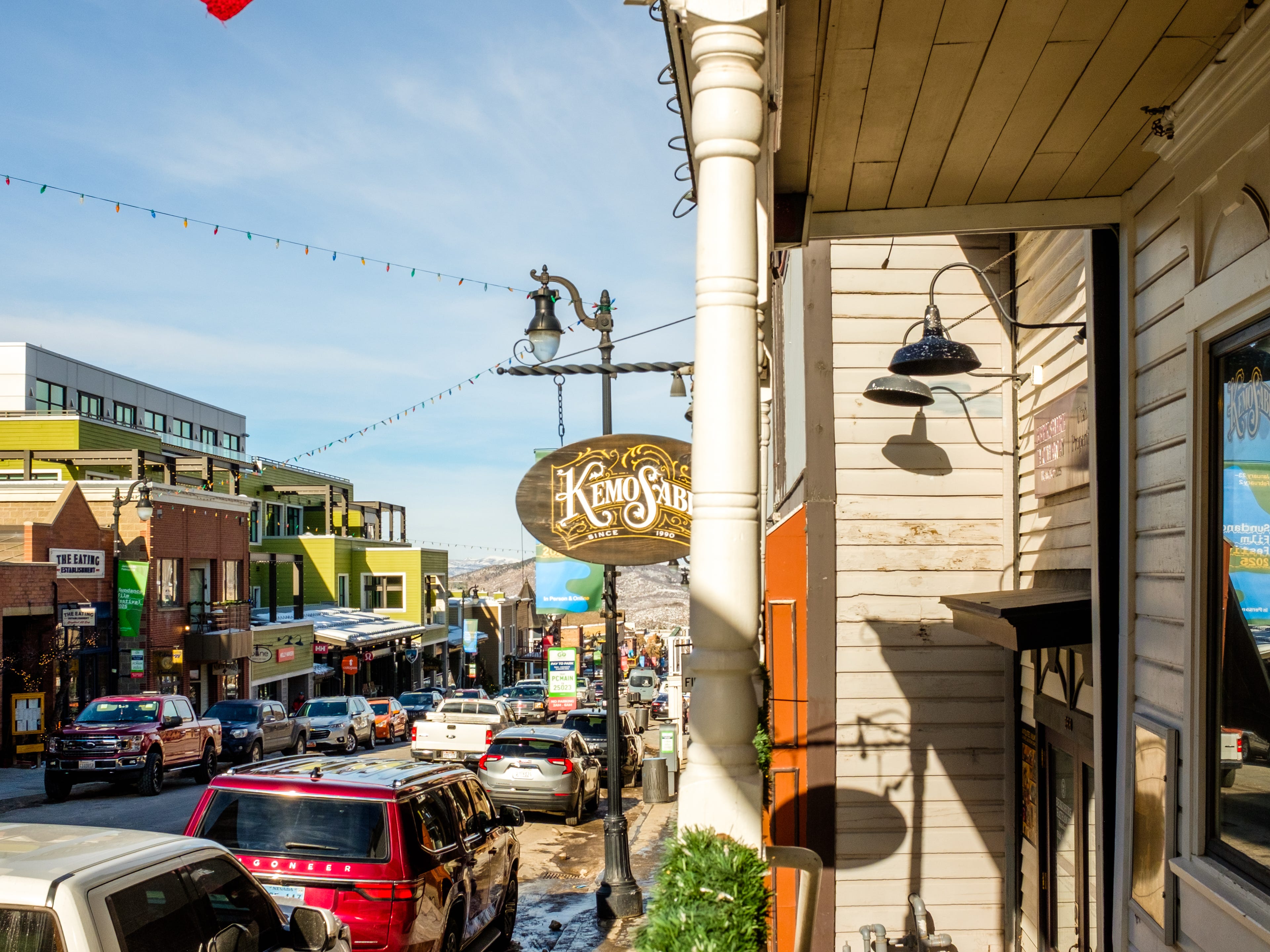 A street shot from the sidewalk lined with shops and resuarants.