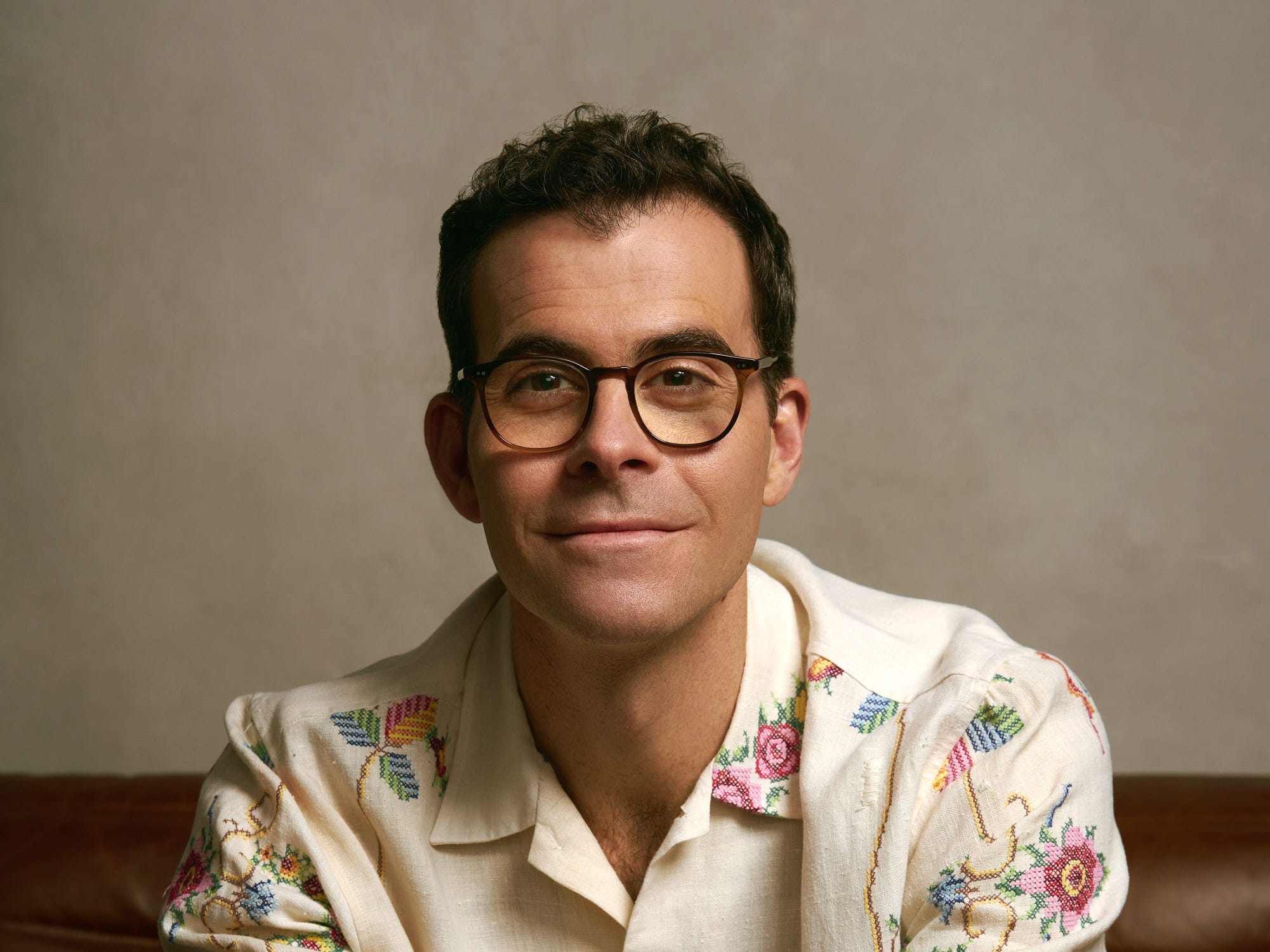 Adam Mosseri sits in white shirt with florals with hands folded
