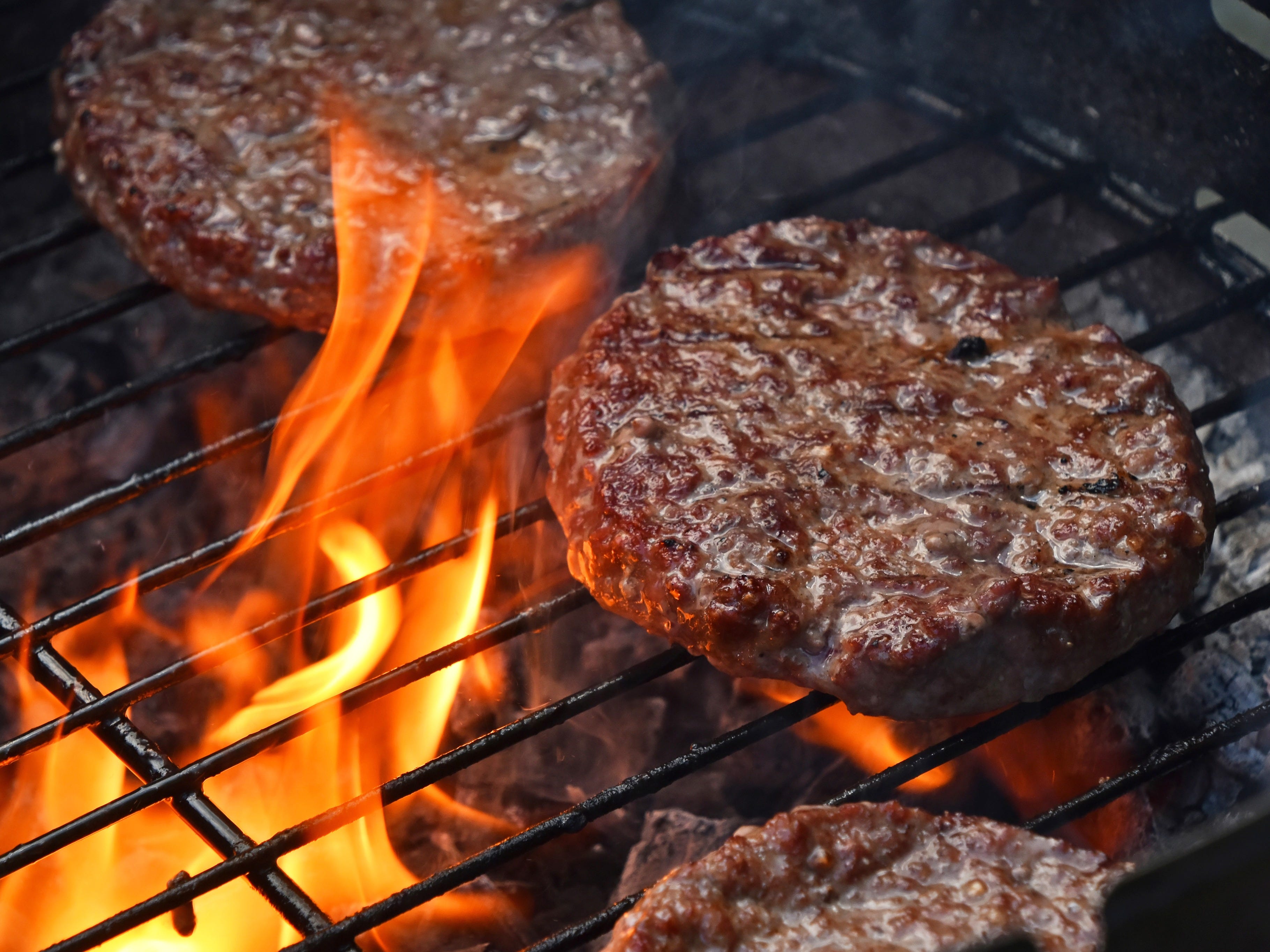burgers on a flaming grill