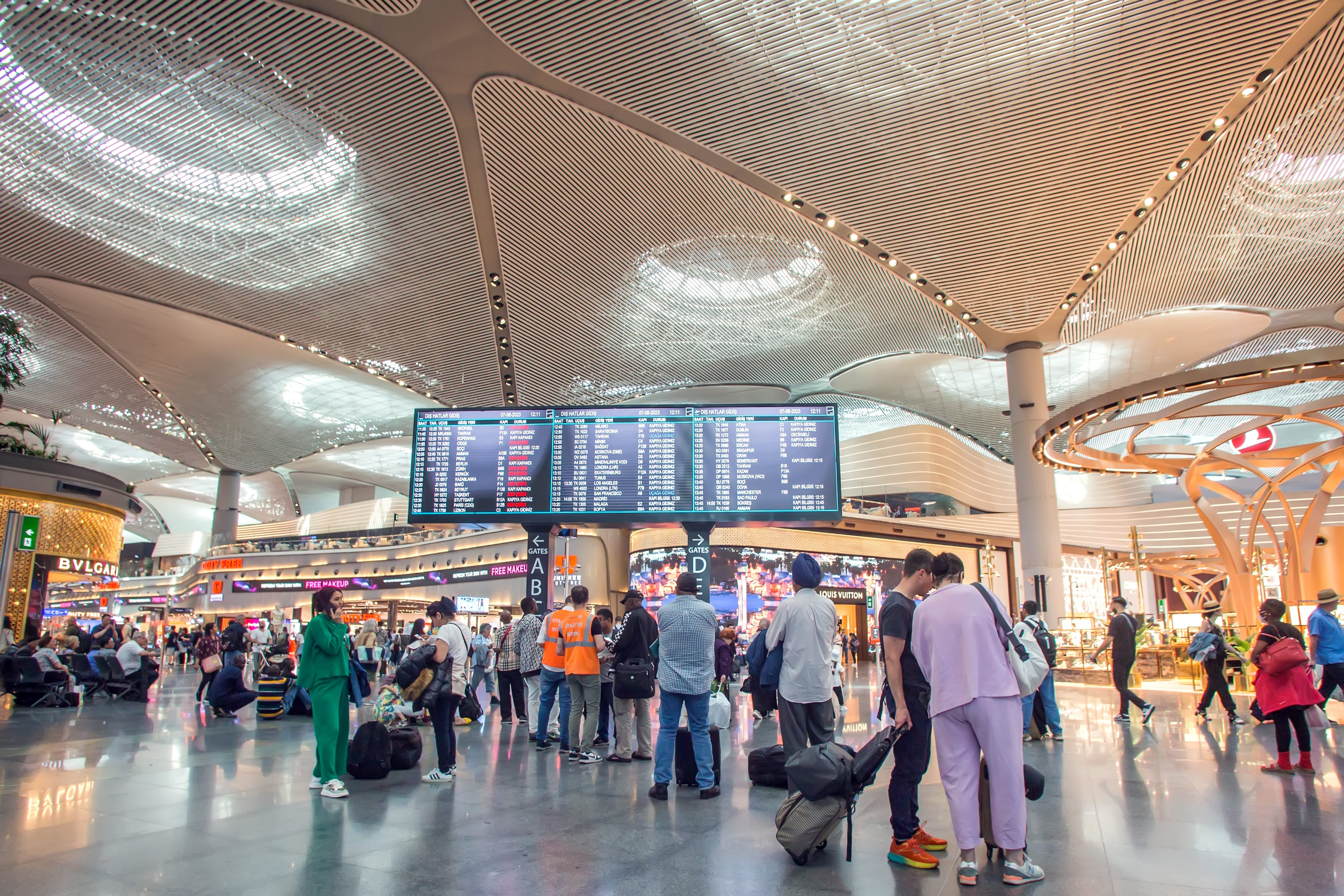Interior of Turkey, Istanbul, Ataturk airport, people looking at departure sign, standing