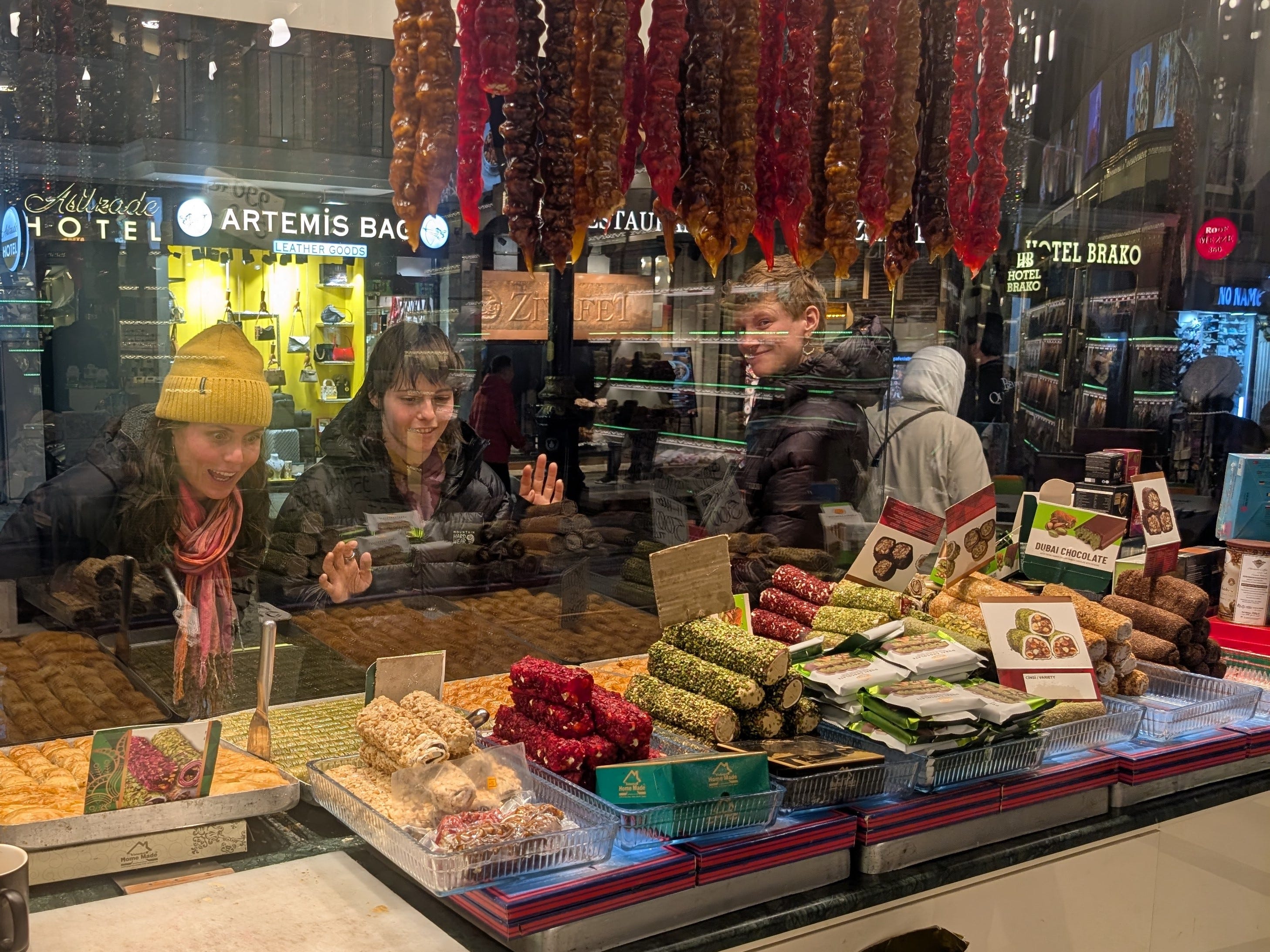 People looking through glass at Turkish desserts and sweets