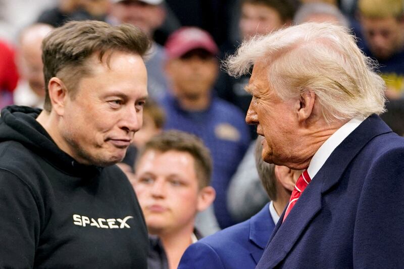Elon Musk greets President Donald Trump as they attend the NCAA men's wrestling championships in Philadelphia, Pennsylvania.