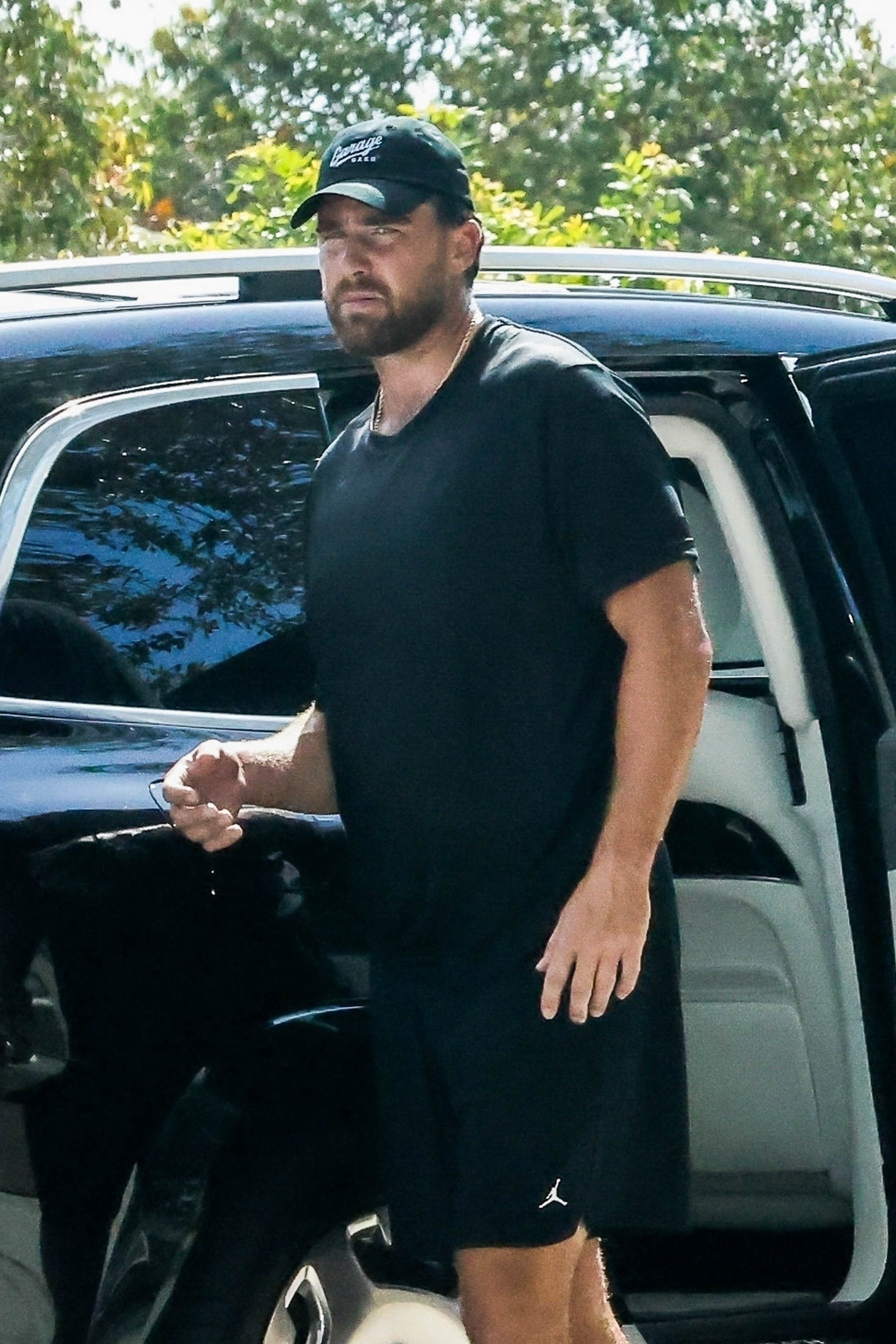 Travis stood outside a black SUV. 