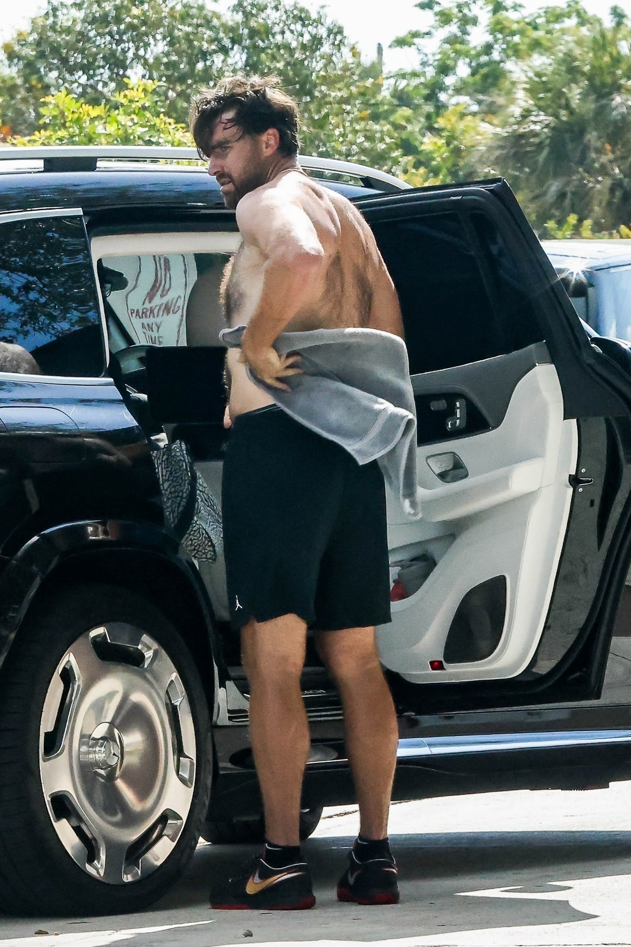 Travis Kelce towels off shirtless. 