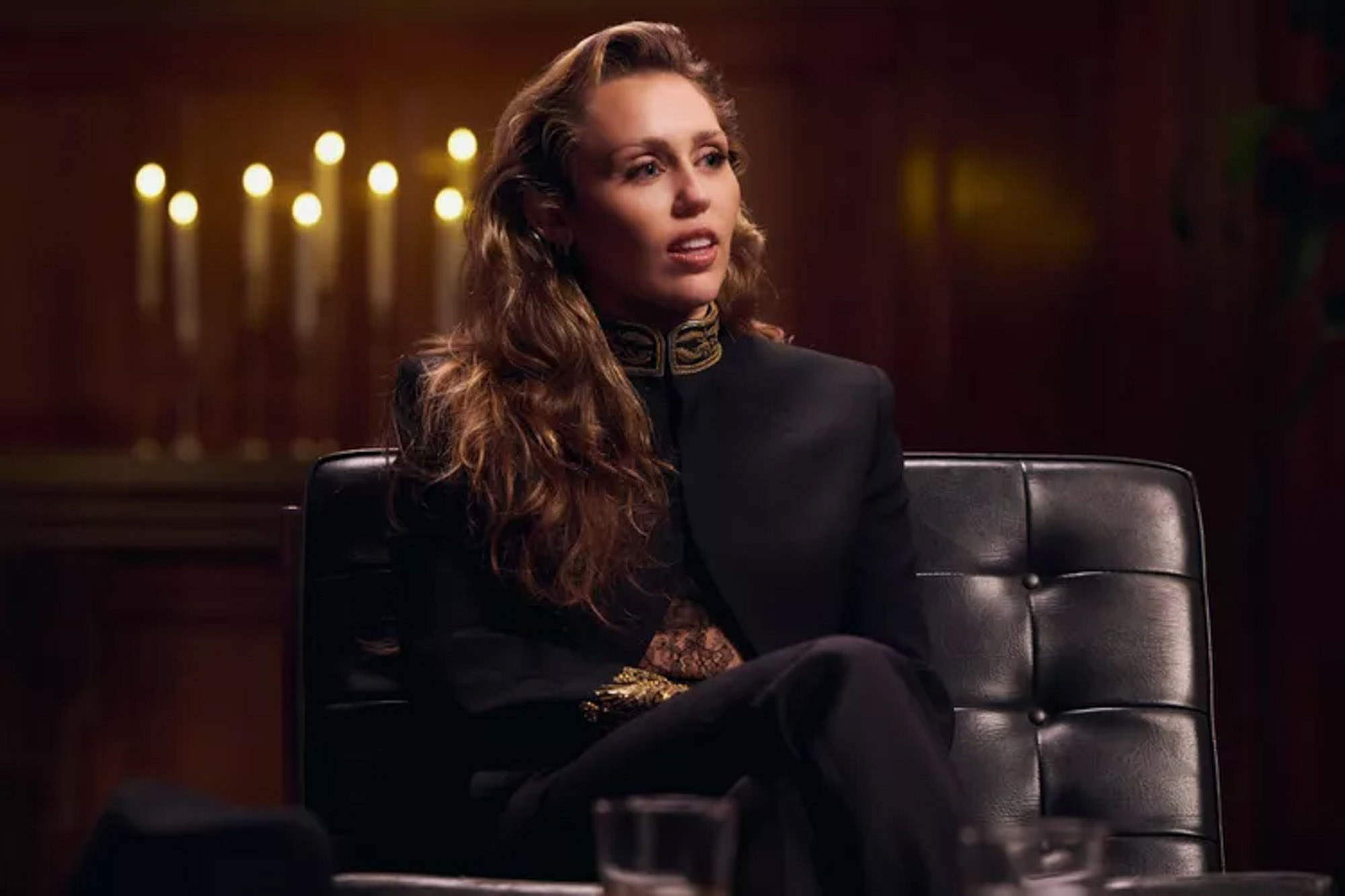 Miley Cyrus sits on a couch during an interview. 