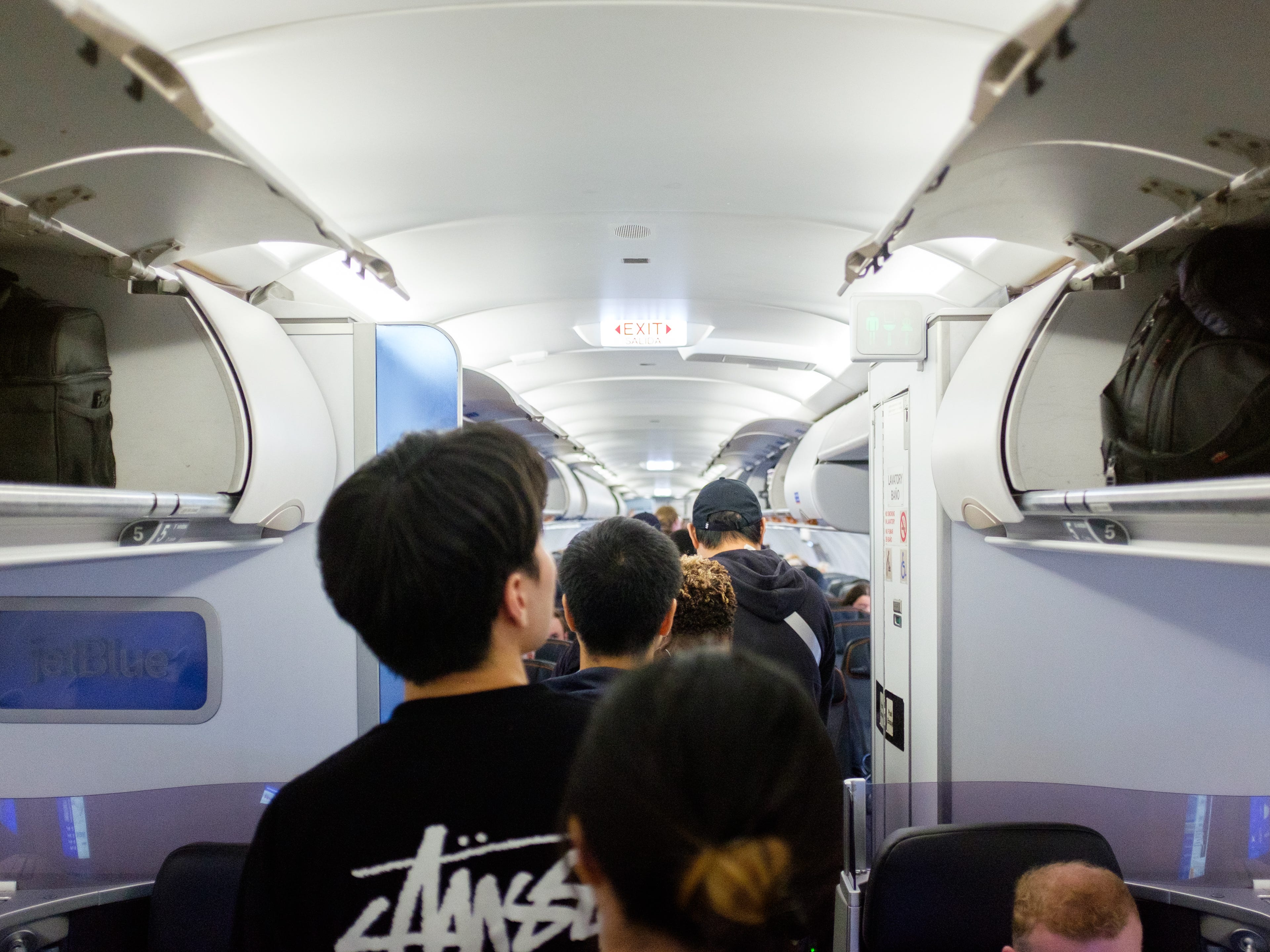 Passengers walk to their seats inside a plane cabin