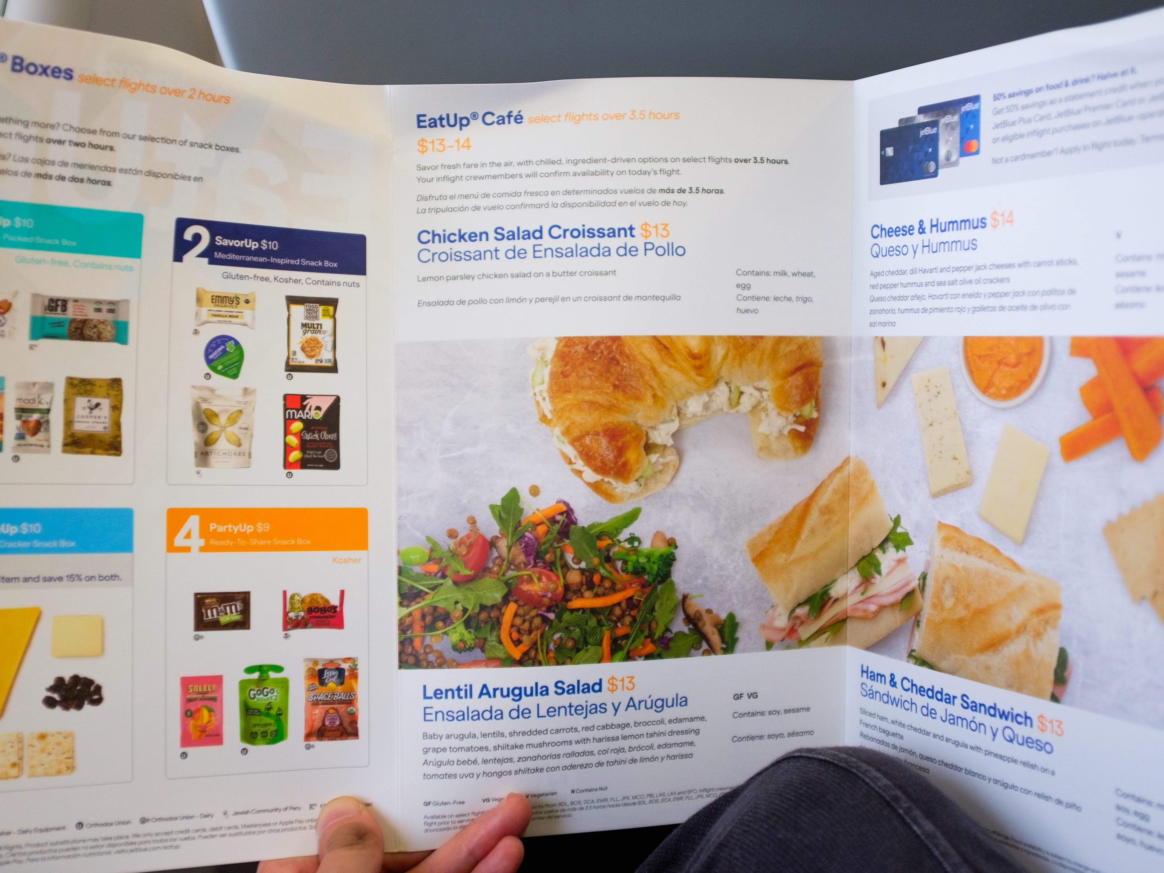 A hand holds an in-flight menu