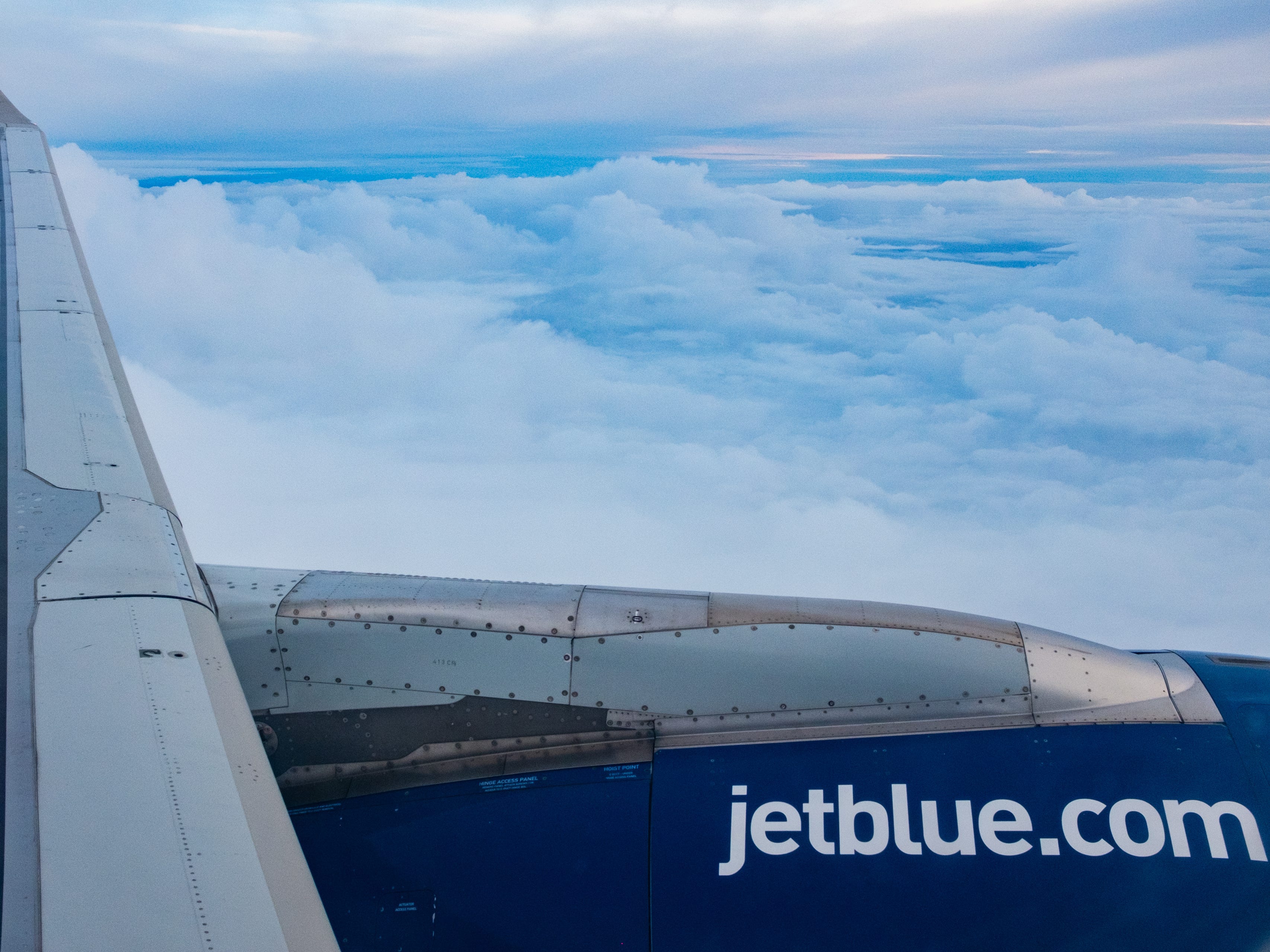 A view out a JetBlue plane window on a cloudy day