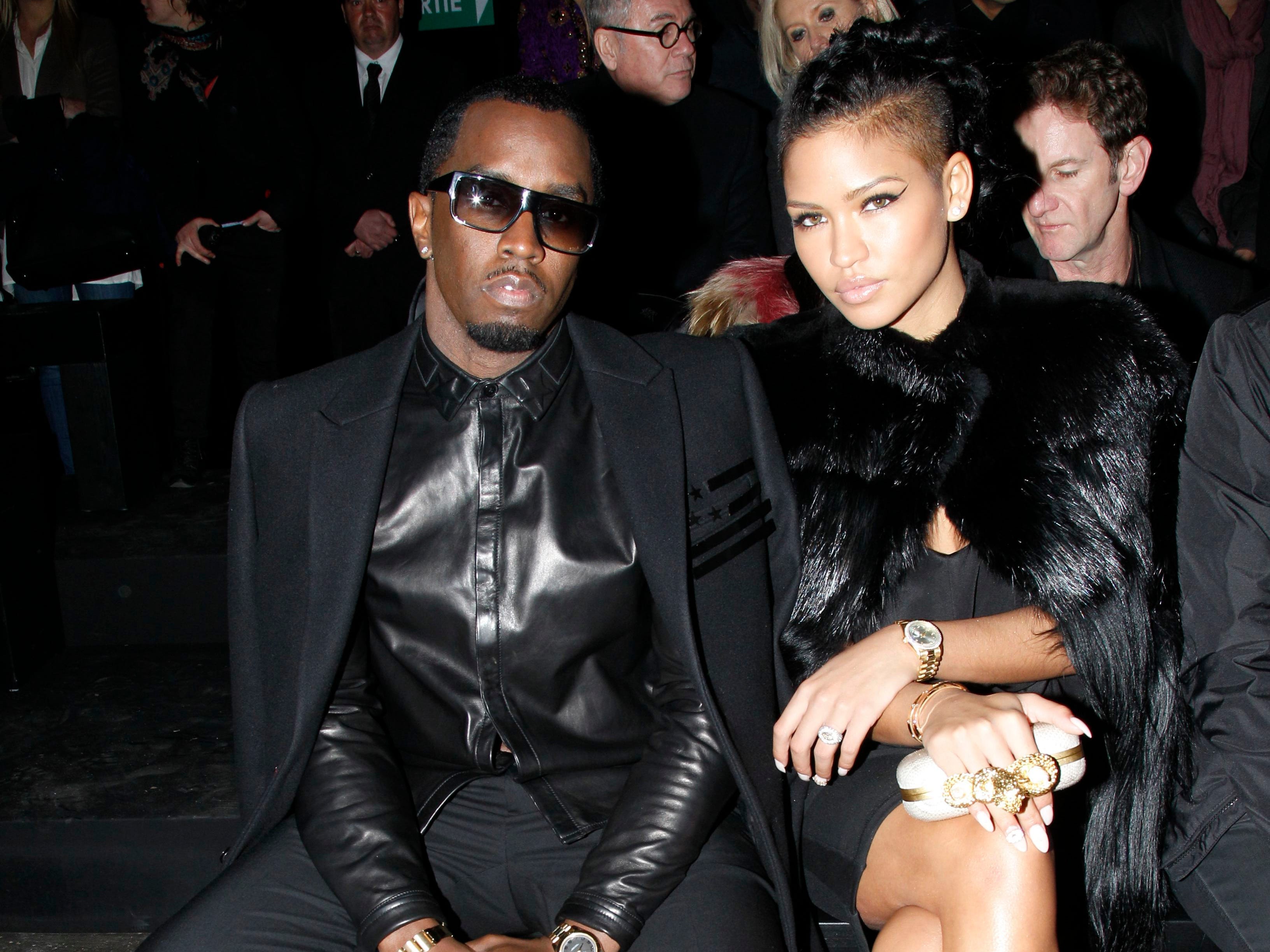 A picture of Diddy and Cassie in black formal outfits sitting down at an event.