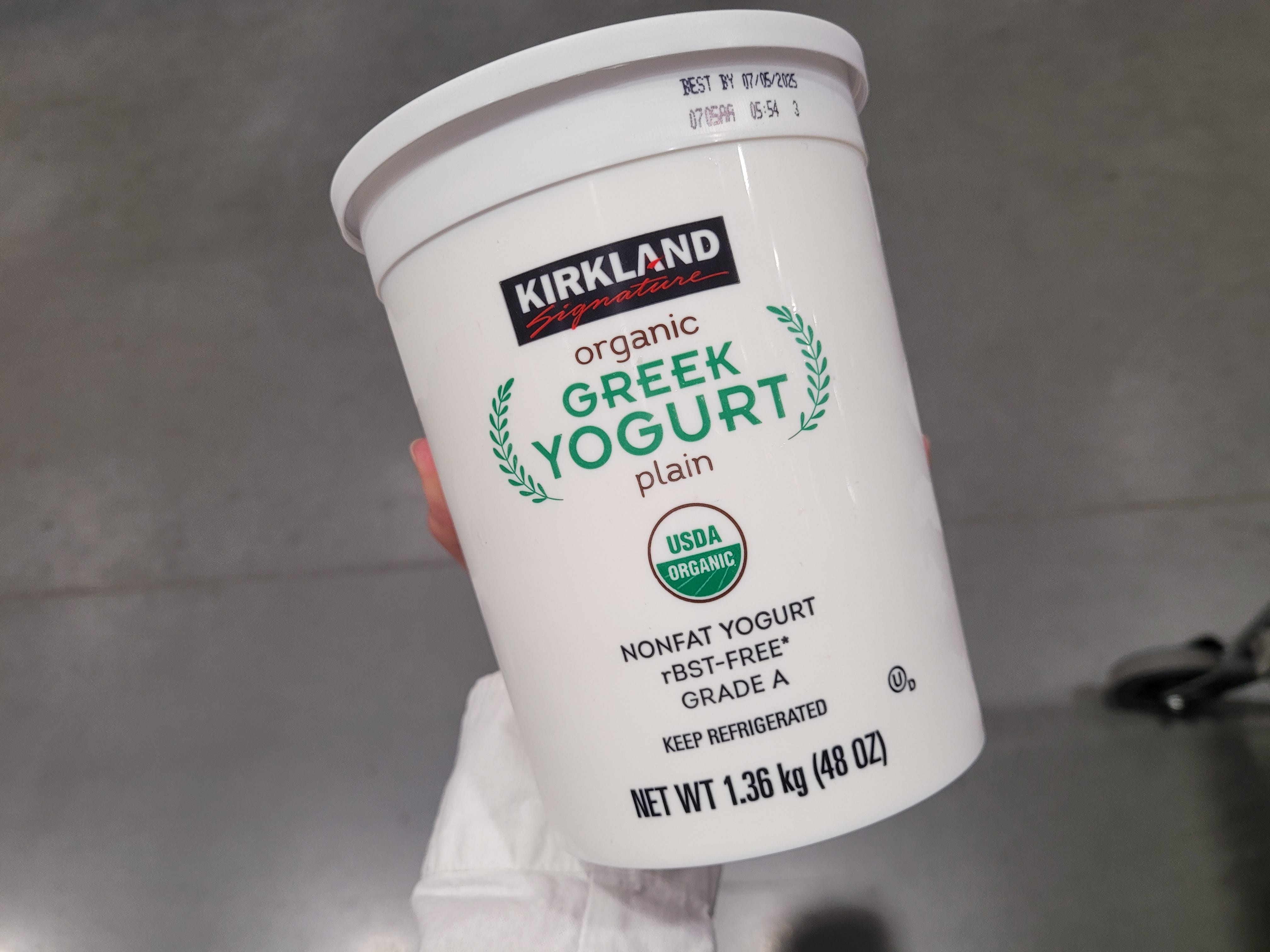 A white tub of Kirkland Signature plain Greek yogurt.