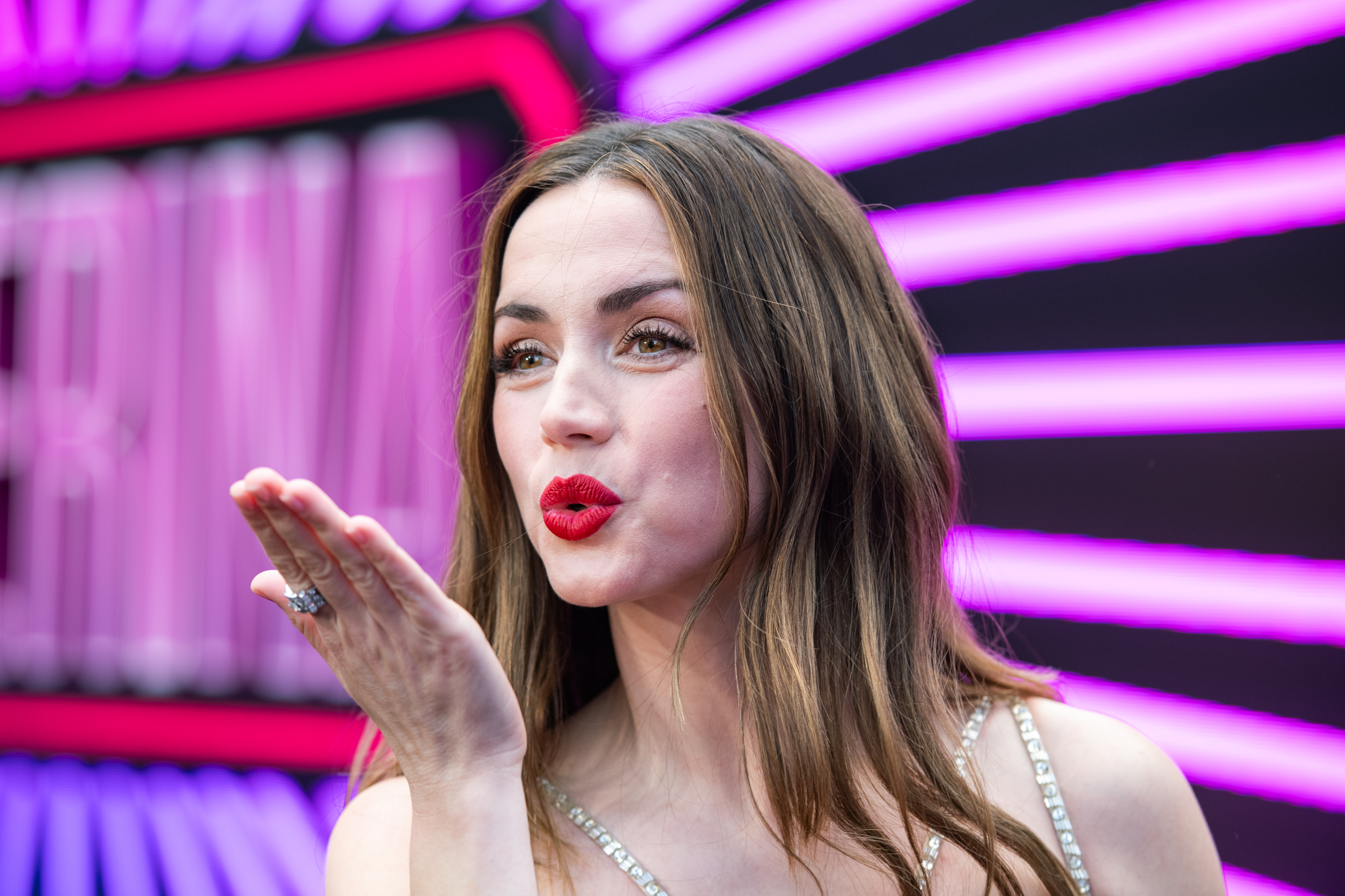Ana de Armas blows a kiss at a formal event. 