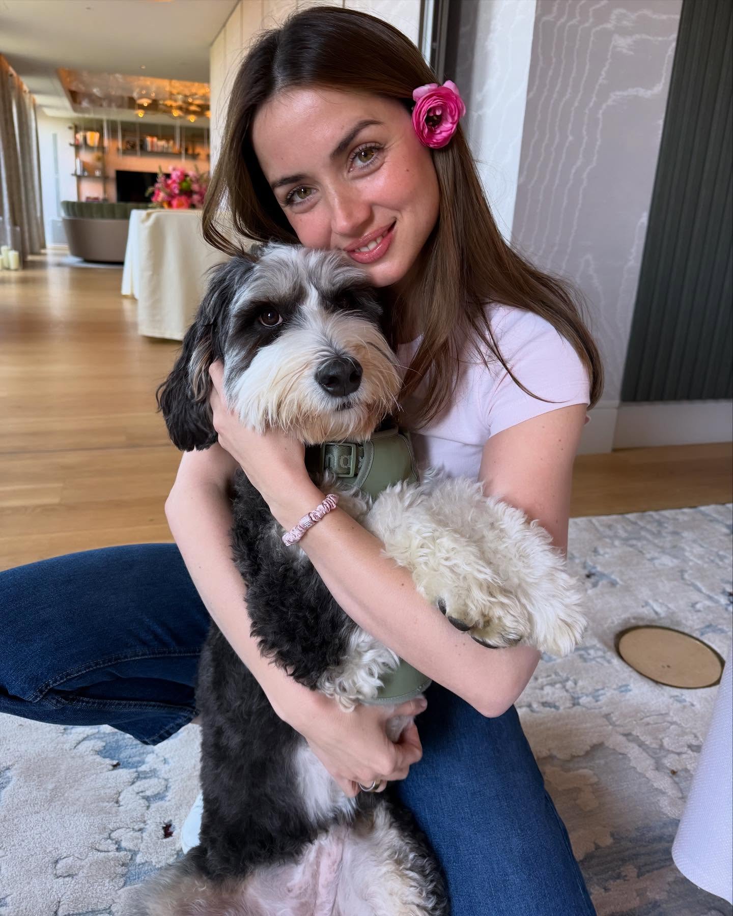 Ana de Armas hugs a dog. 