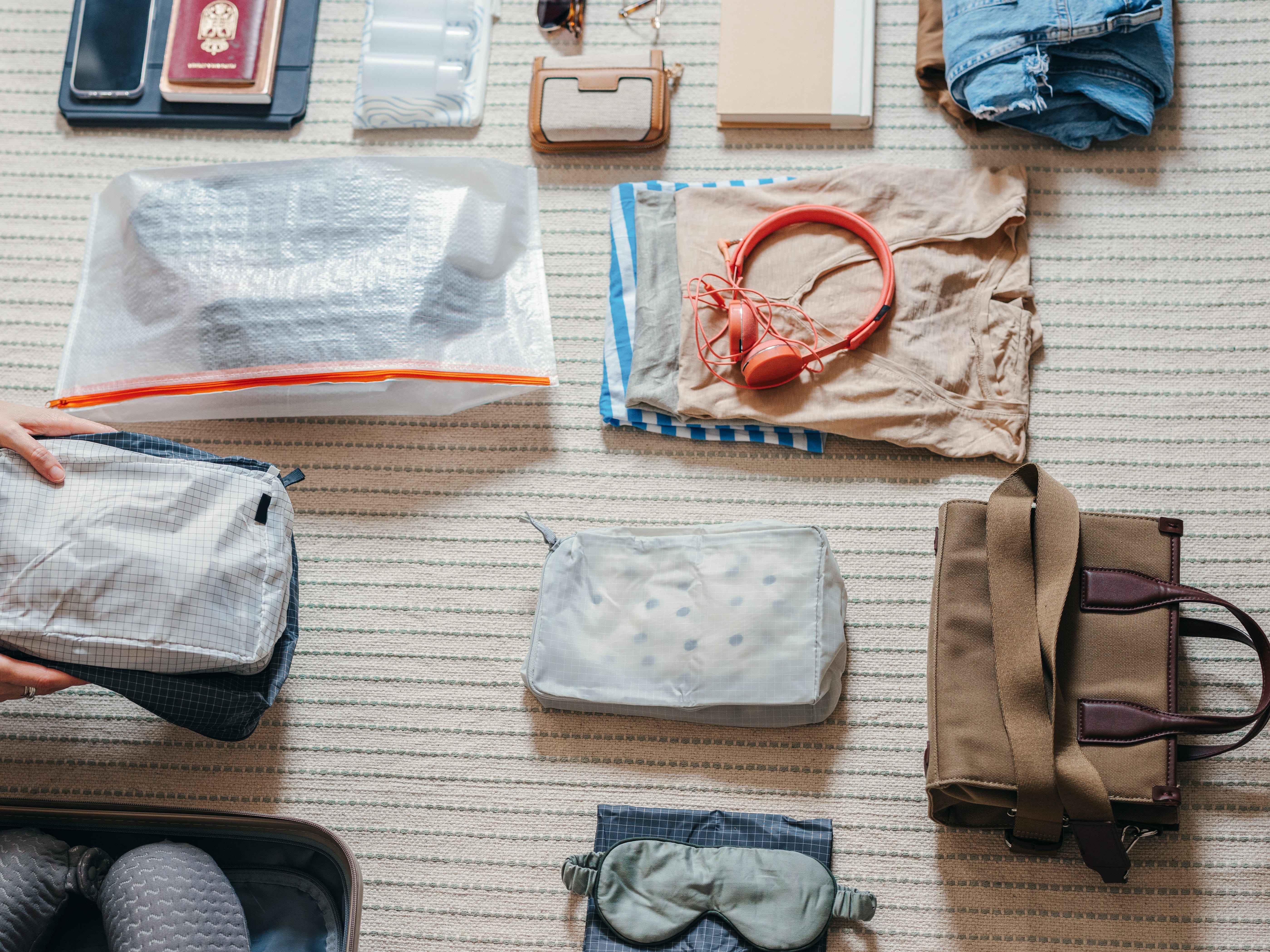 A woman packing a carryon bag for travel.