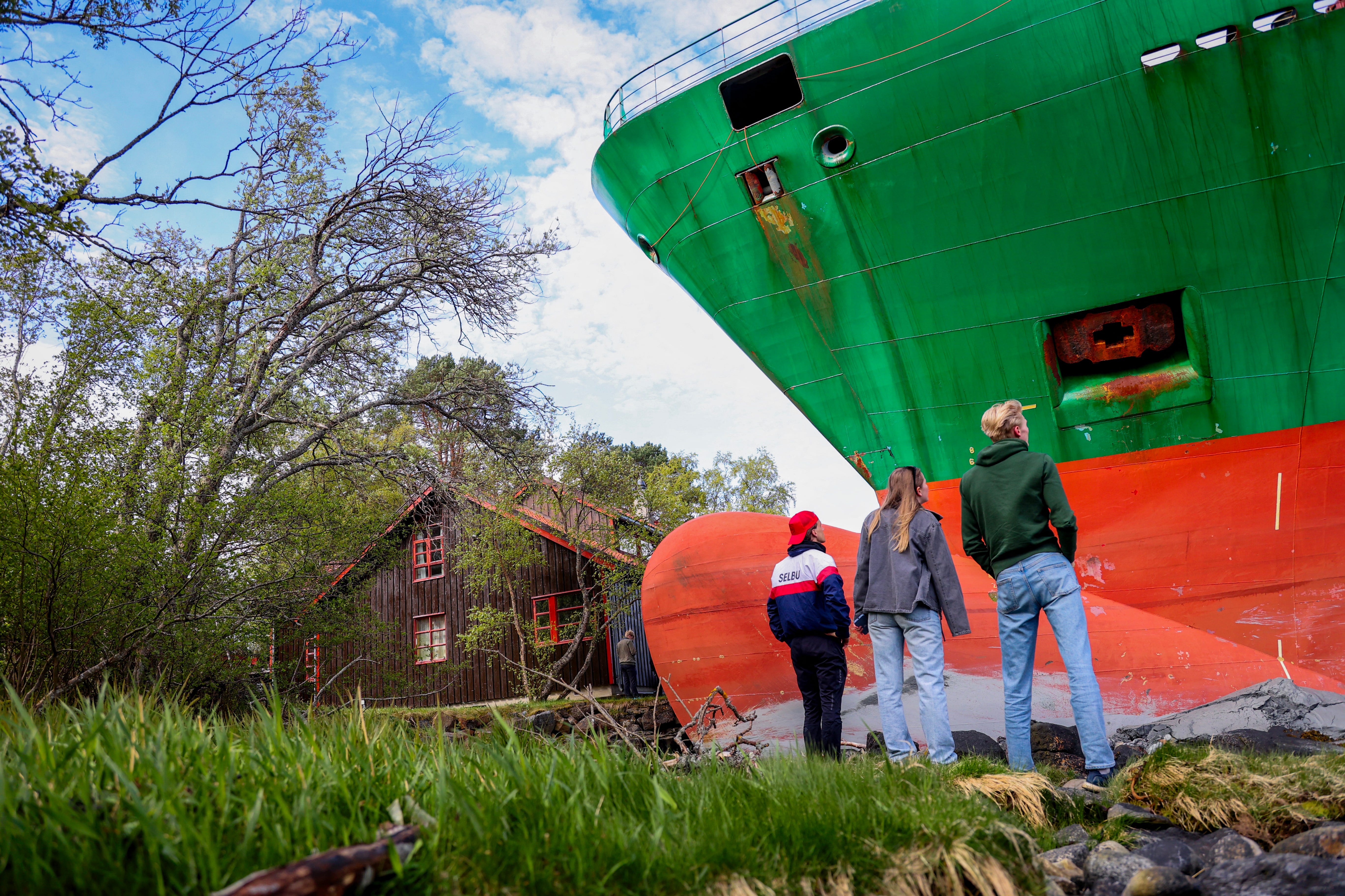 Bystanders taking a look at a container ship that ran aground in Norway.