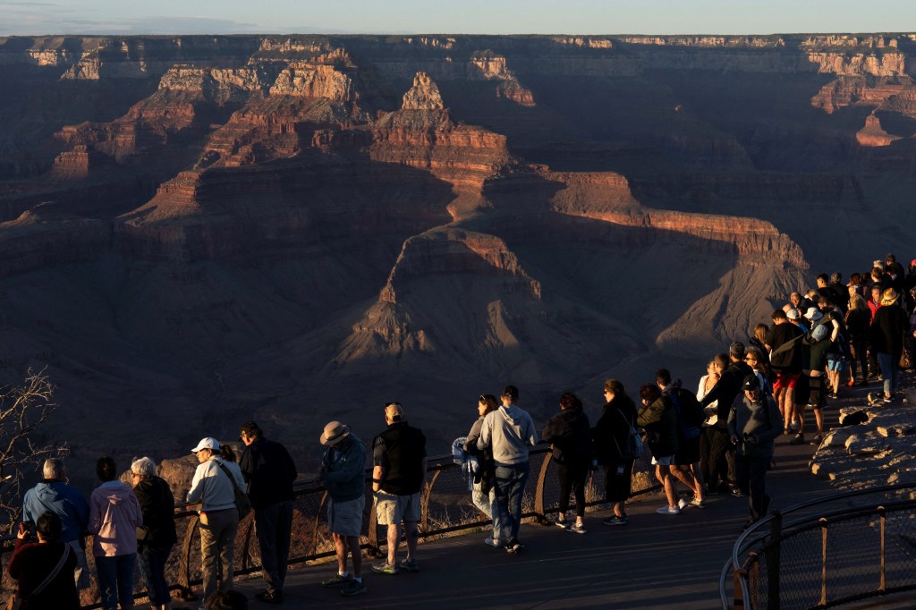 Tourist watch the sunset from an observation platform overlooking the Grand Canyon in Tusayan, Arizona, on May 16, 2025.