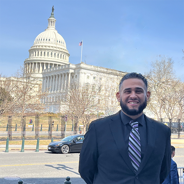Eric Rodriguez poses for a photo outside the US Capitol building during a trip to DC.