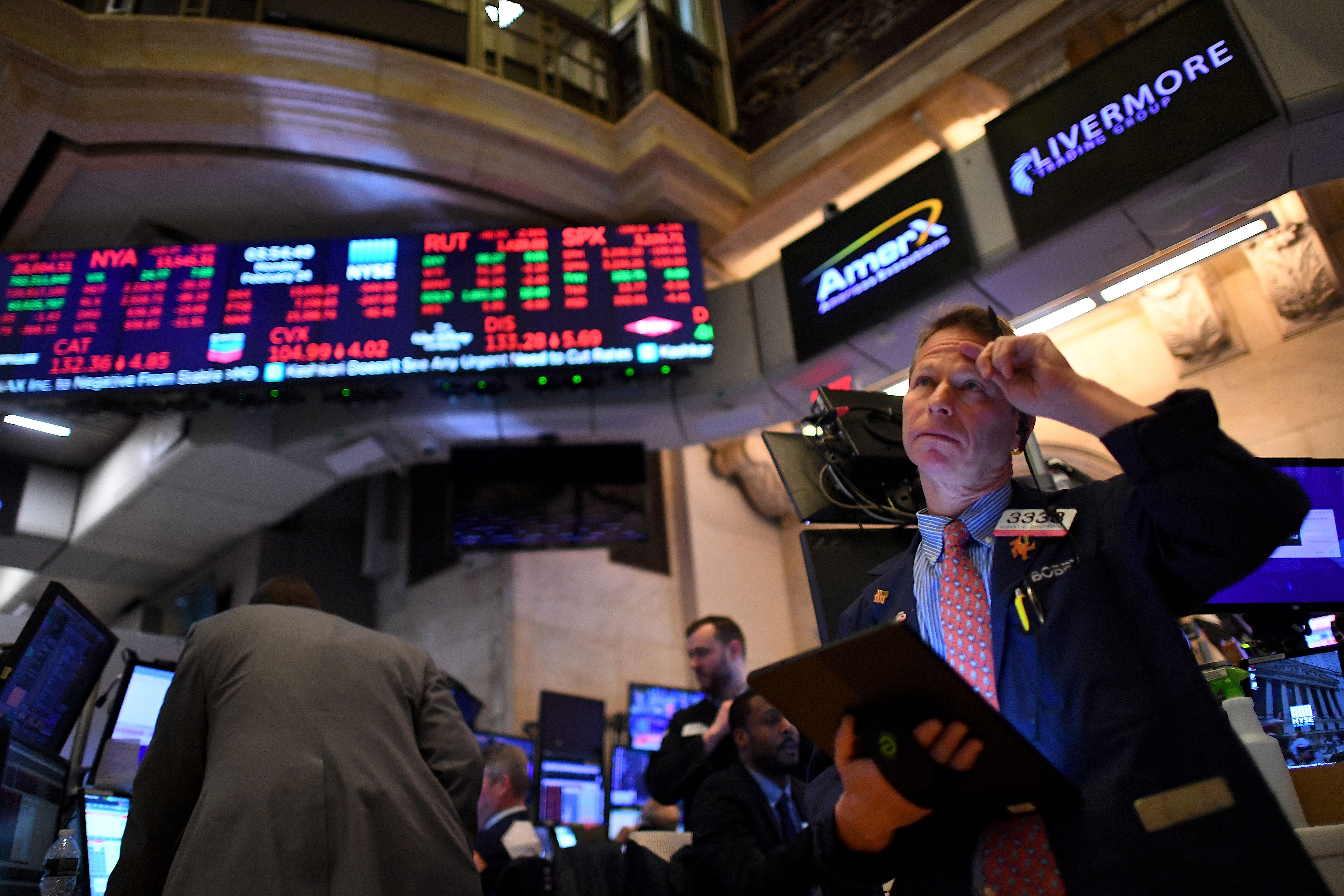 NYSE trader with red screens in the background