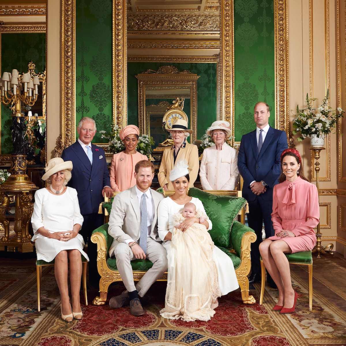 Royal family members pose for a group photo in a room with green wallpaper and gold mirrors to celebrate Prince Archie's christening.