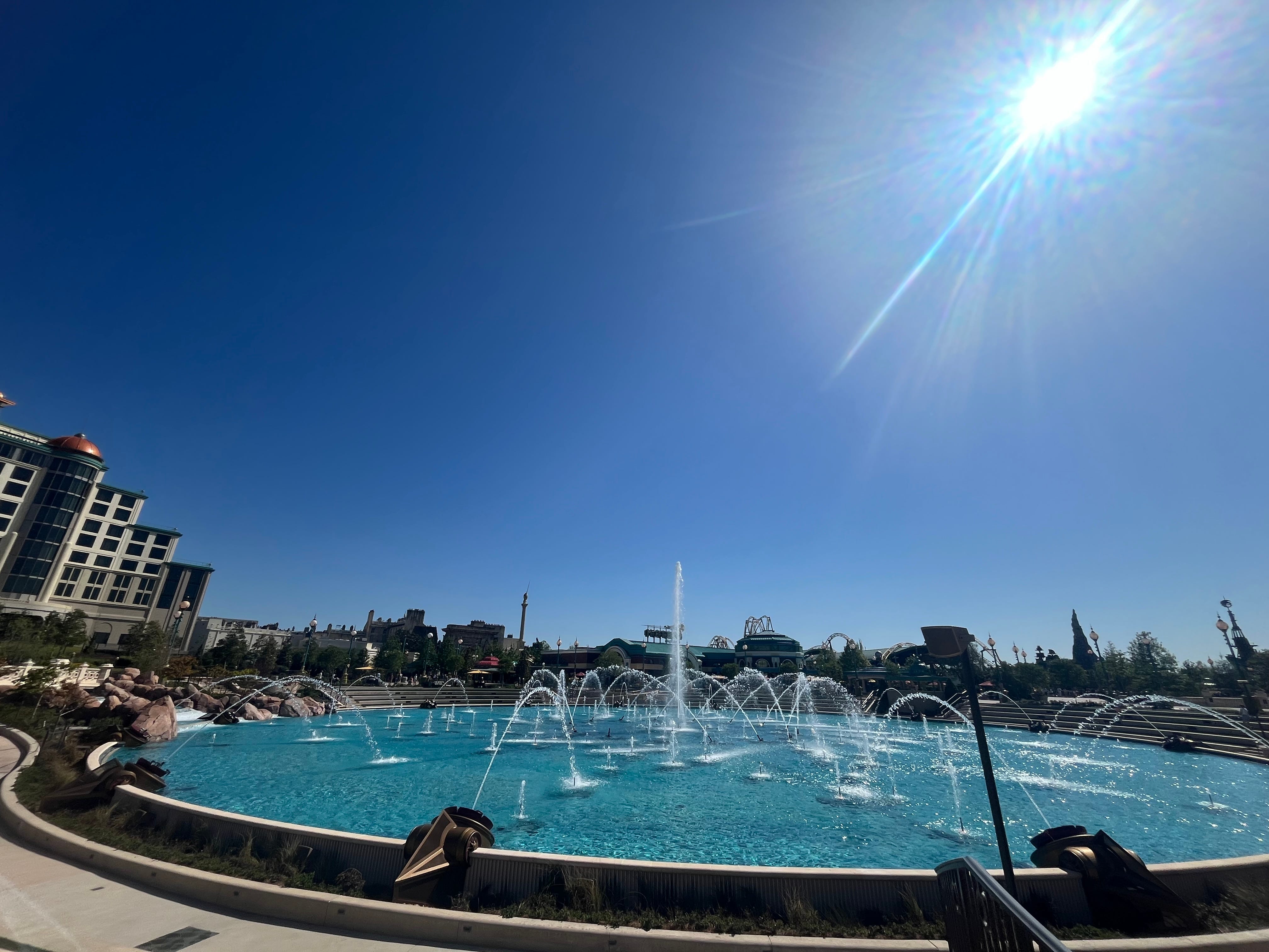 Sun blazing above fountain in Epic Universe