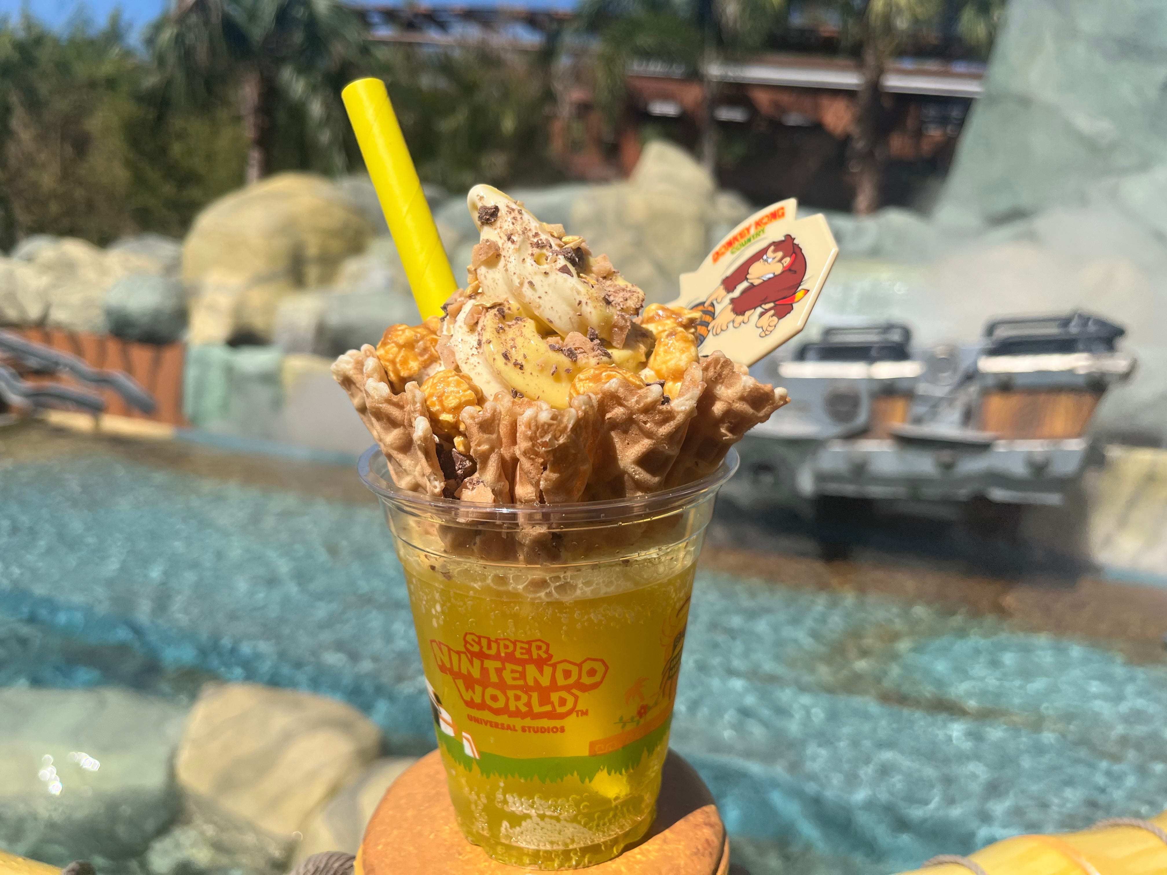 DK Crush float - yellow soda in a cup topped with ice cream, toppings, and a straw