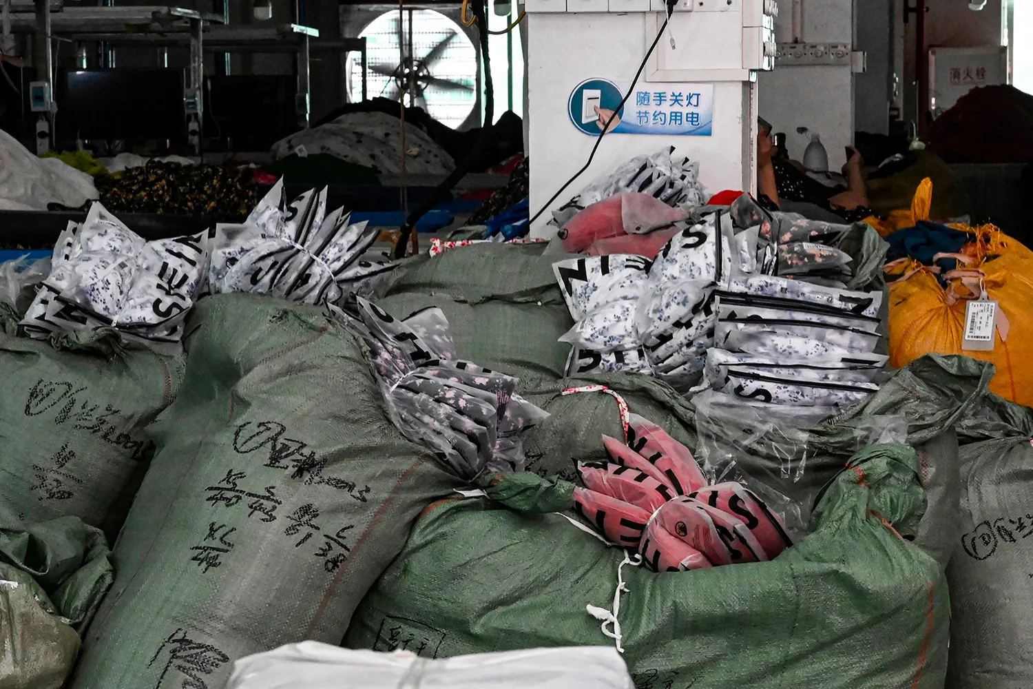 Large piles of garment packages from Shein in a factory.