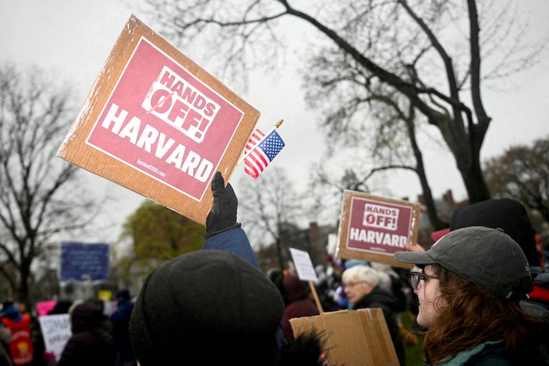 Demonstrators with signs reading "Hands off Harvard" rally on Cambridge Common in a protest against the federal government in Cambridge, Massachusetts.
