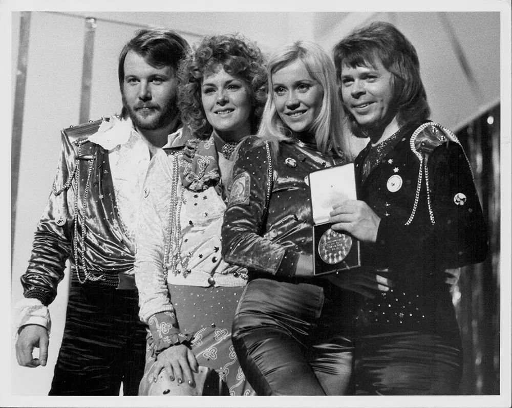Four band members post for a photo.
