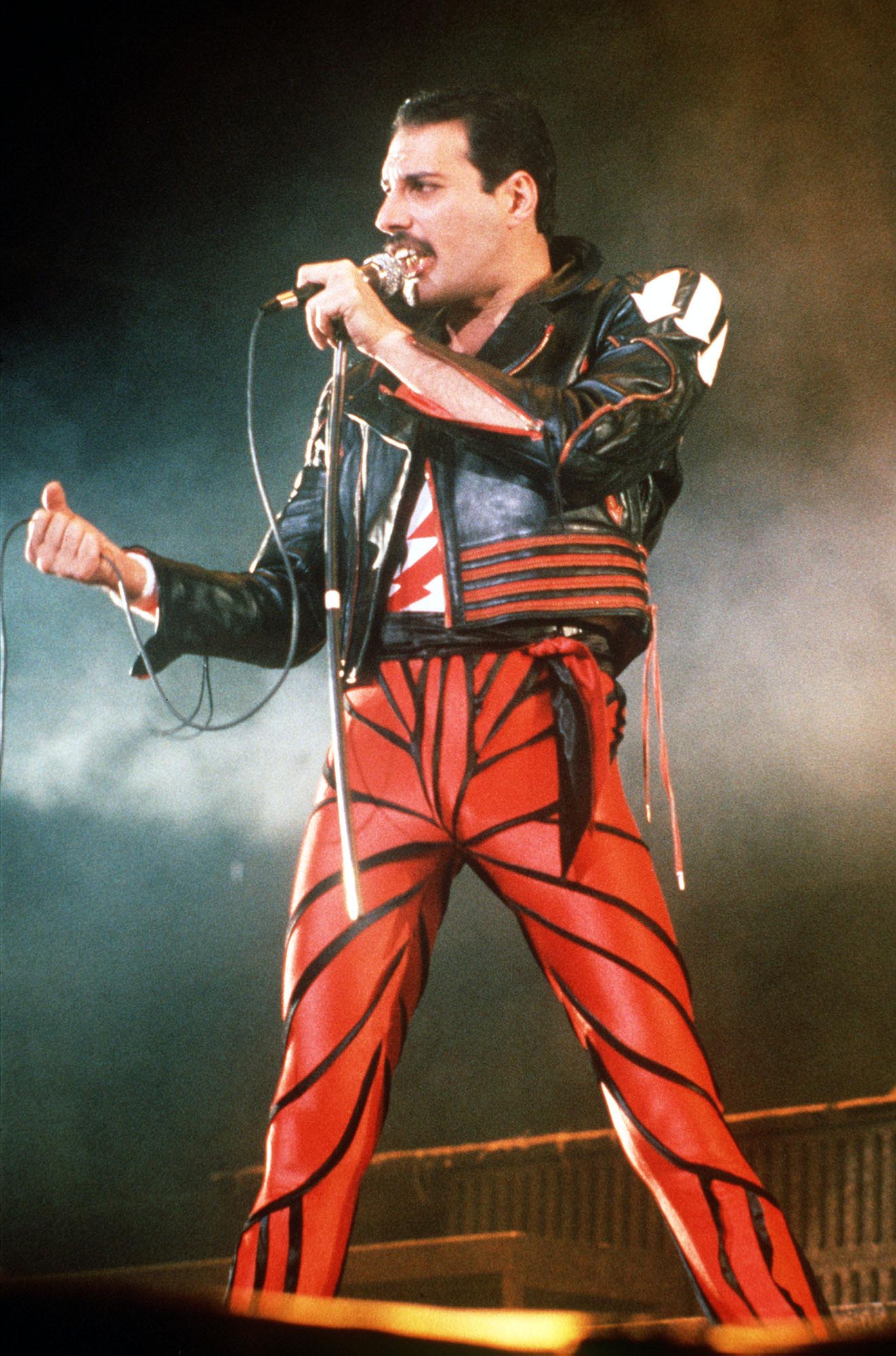 Freddie Mercury with a microphone onstage. 
