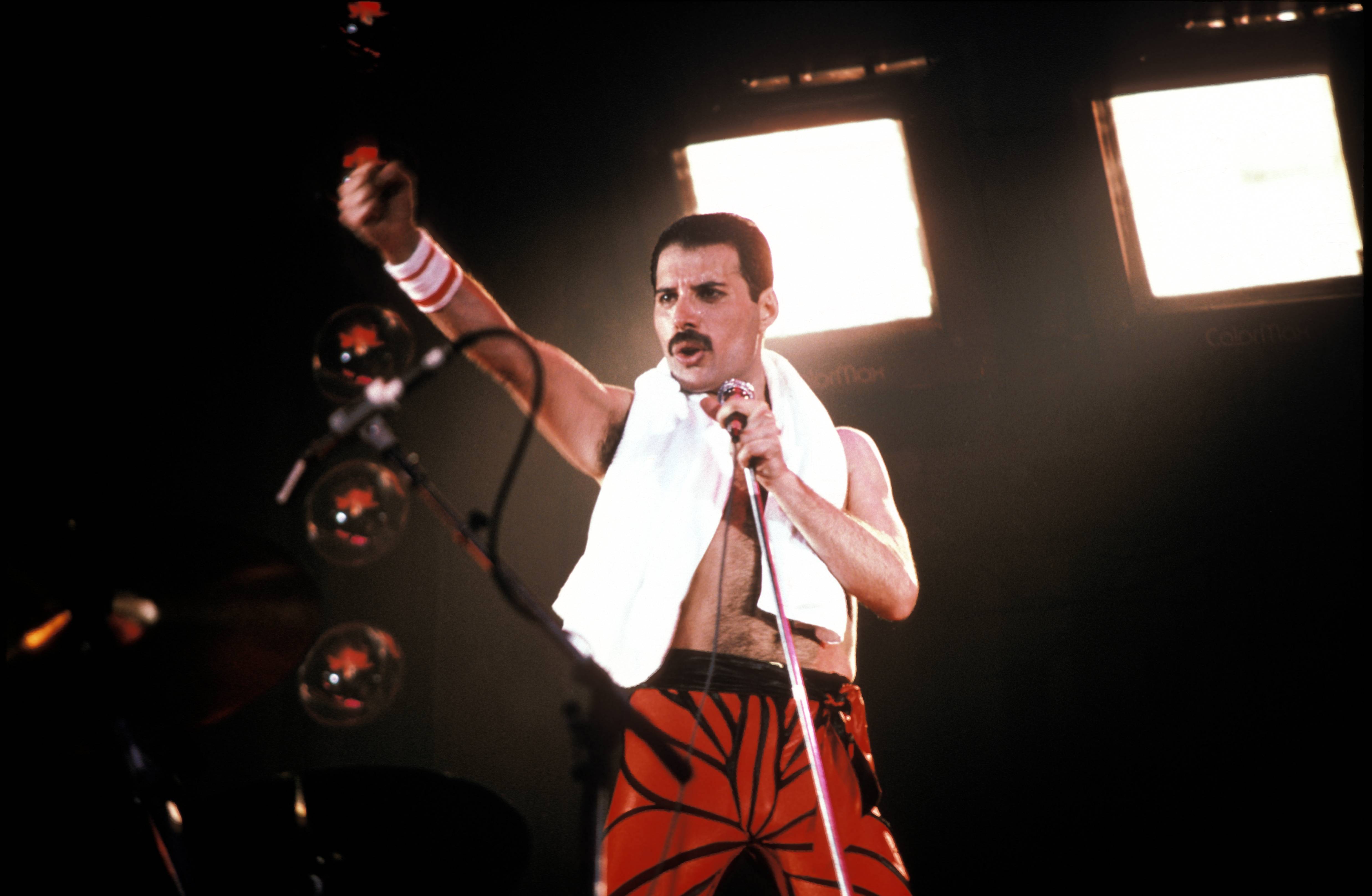 Freddie Mercury performing shirtless with a towel. 
