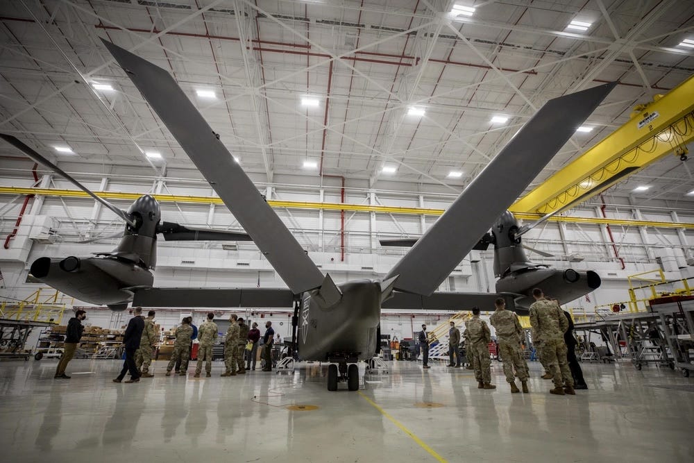 US Army soldiers stand near a V-280 rotorcraft in a hangar.