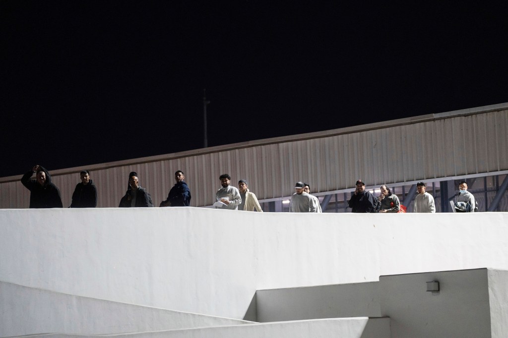 Migrants walk into Mexico after being deported from the US at El Chaparral pedestrian border bridge in Tijuana, Mexico on Jan. 21, 2025.