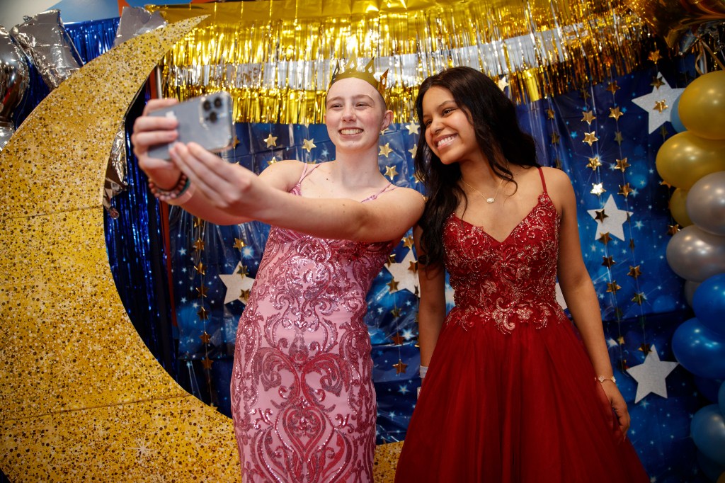 Jazzy and Samantha take a selfie against starry night backdrop at Memorial Sloan Kettering prom. 