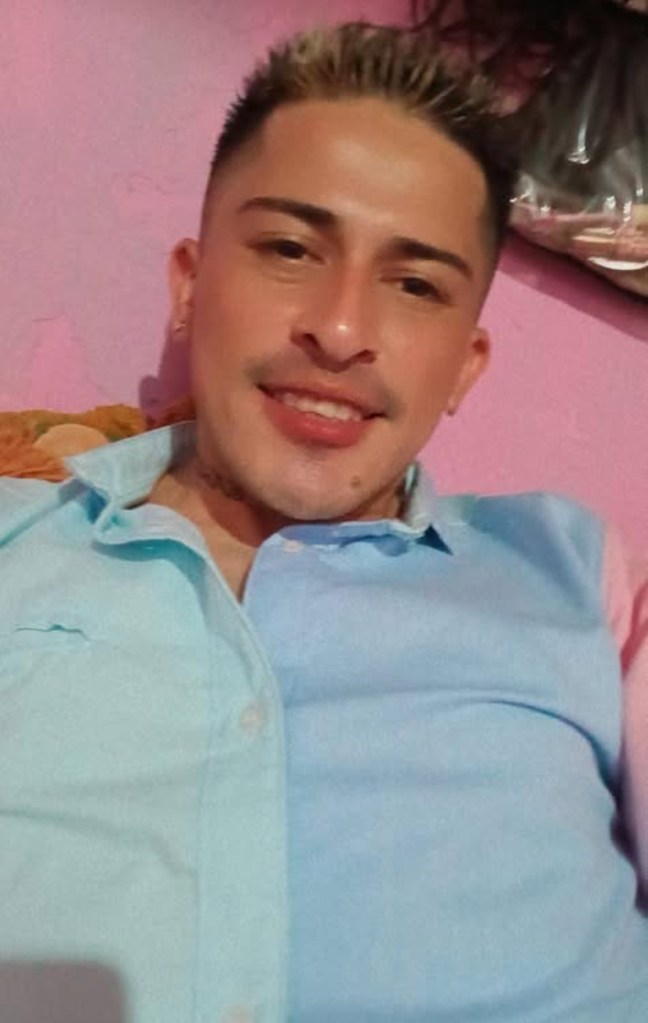 selfie of Jorge Flores Maldonado in a light blue and pale turquoise button down, smiling