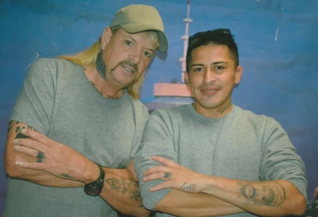 Joe Exotic and Jorge Flores Maldonado posing together each with their arms crossed in front of them and wearing grey shirts.