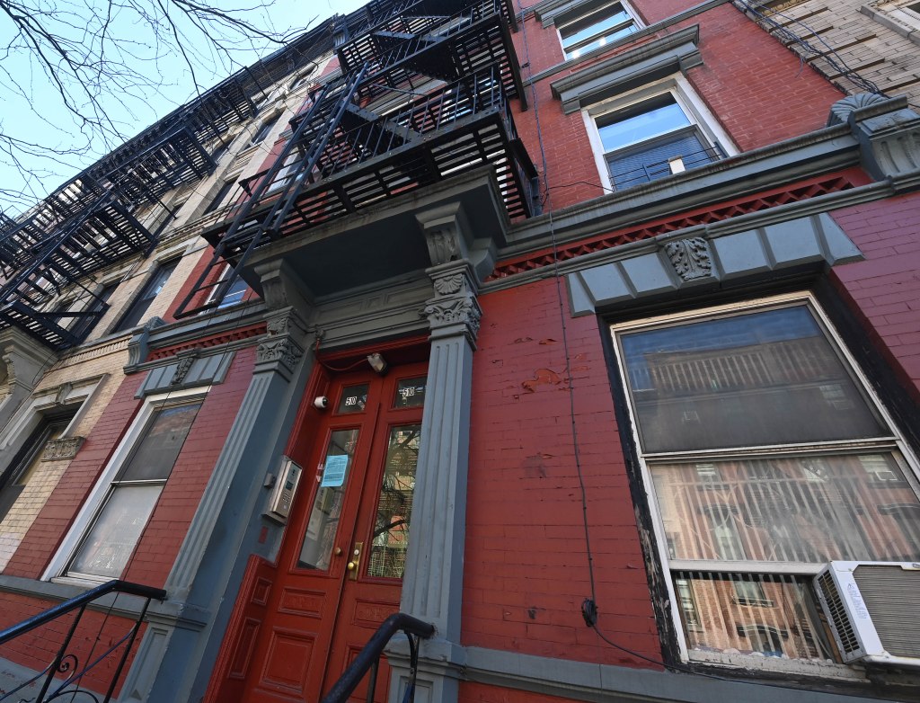 exterior pf a building in the east village with red brick and grey trim and fire escapes on the front