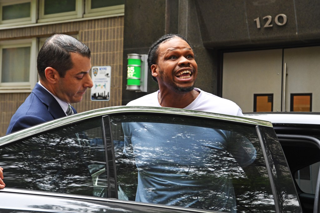 Girard appears to smile as he's put into an unmarked police car.